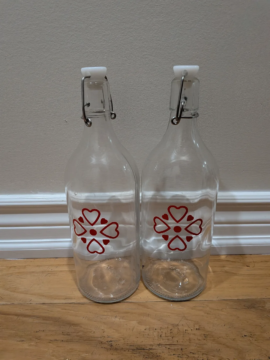 Two Clear Glass Bottles with Red Heart Design thumbnail