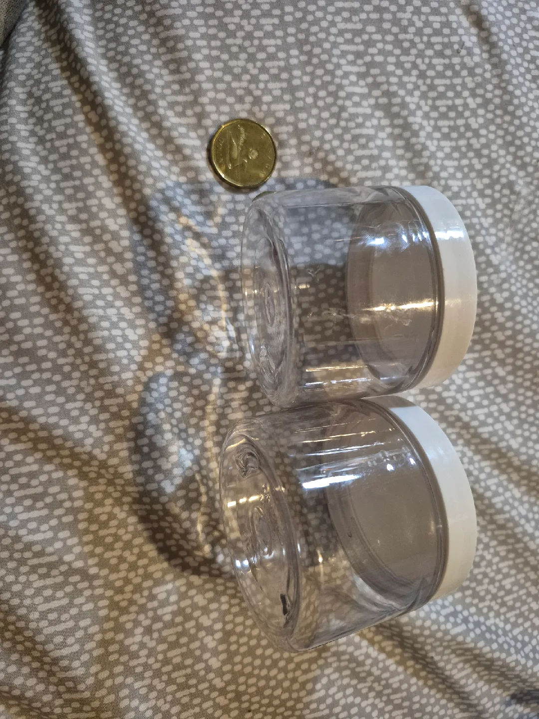 Two Clear Plastic Jars with White Lids