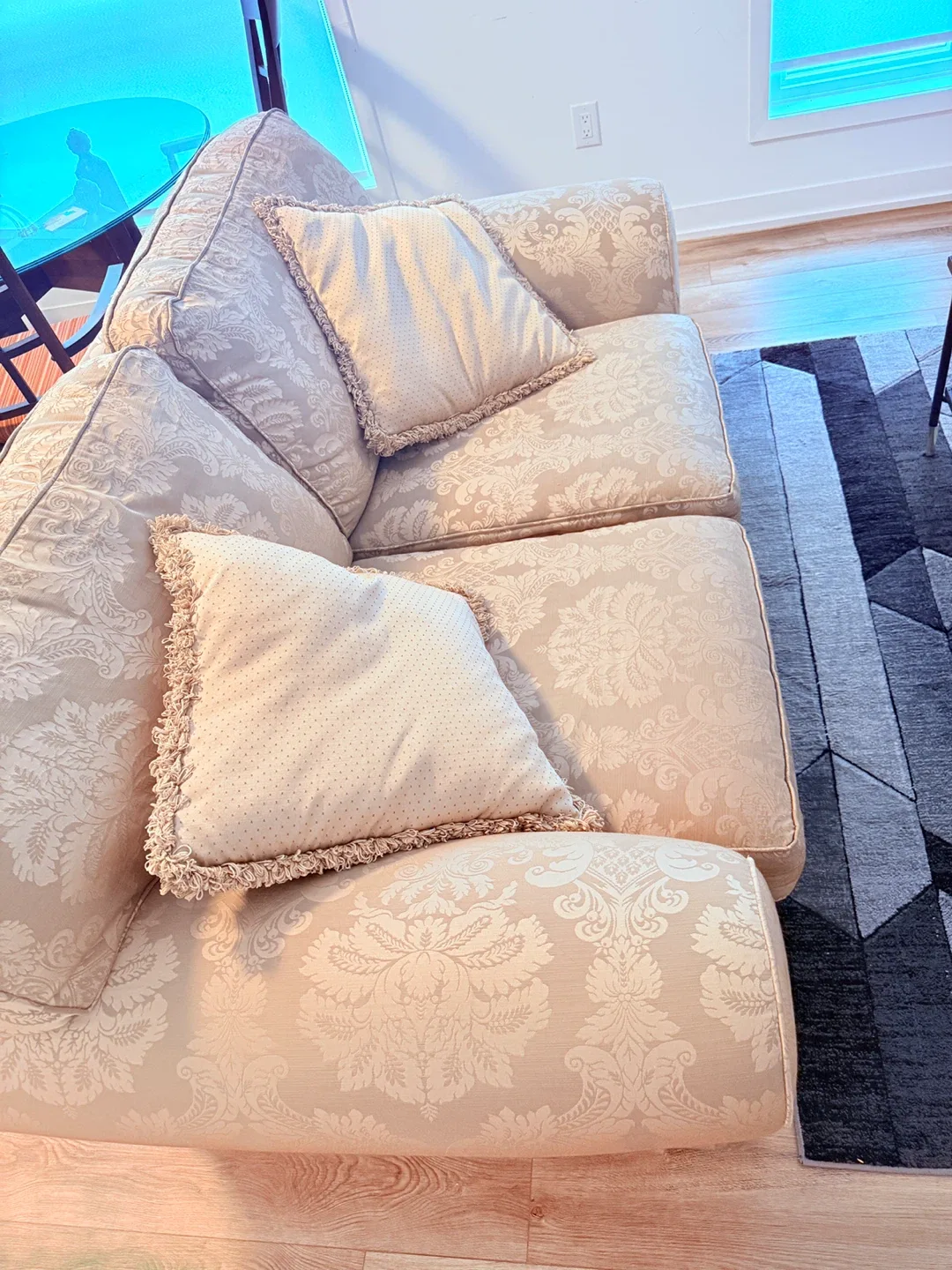 Patterned Beige Sofa with 2 Throw Pillows and a table