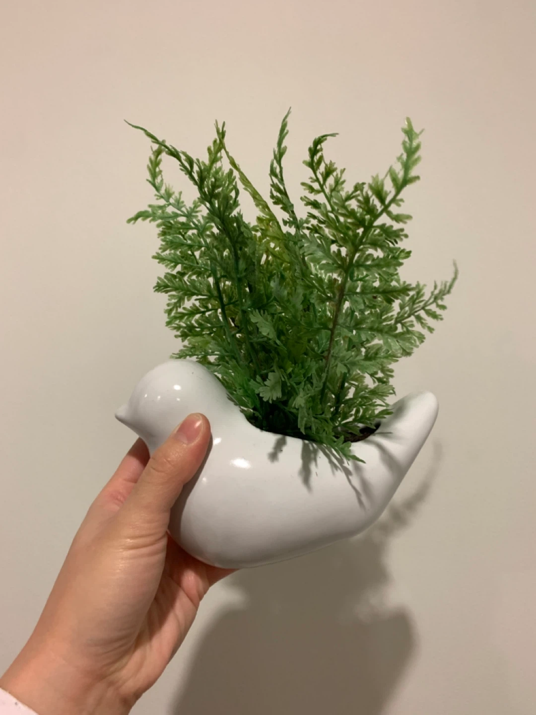 White ceramic bird planter with plant