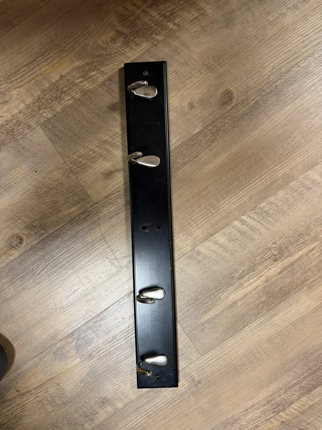 Black metal wall-mounted coat rack