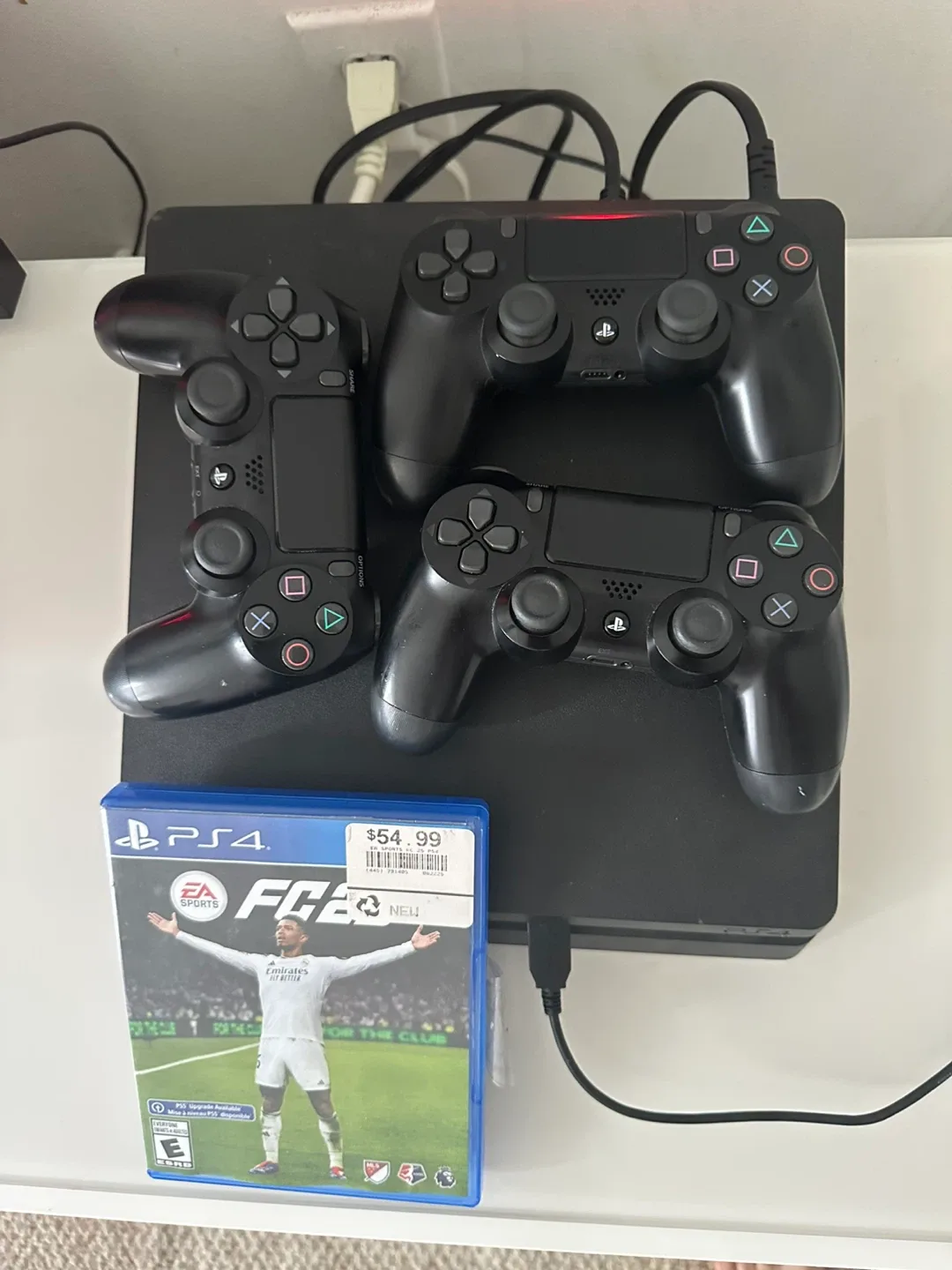 PS4 with three controllers and FIFA 25