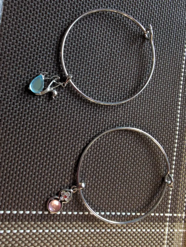 Two Silver Bangle Bracelets with Charms