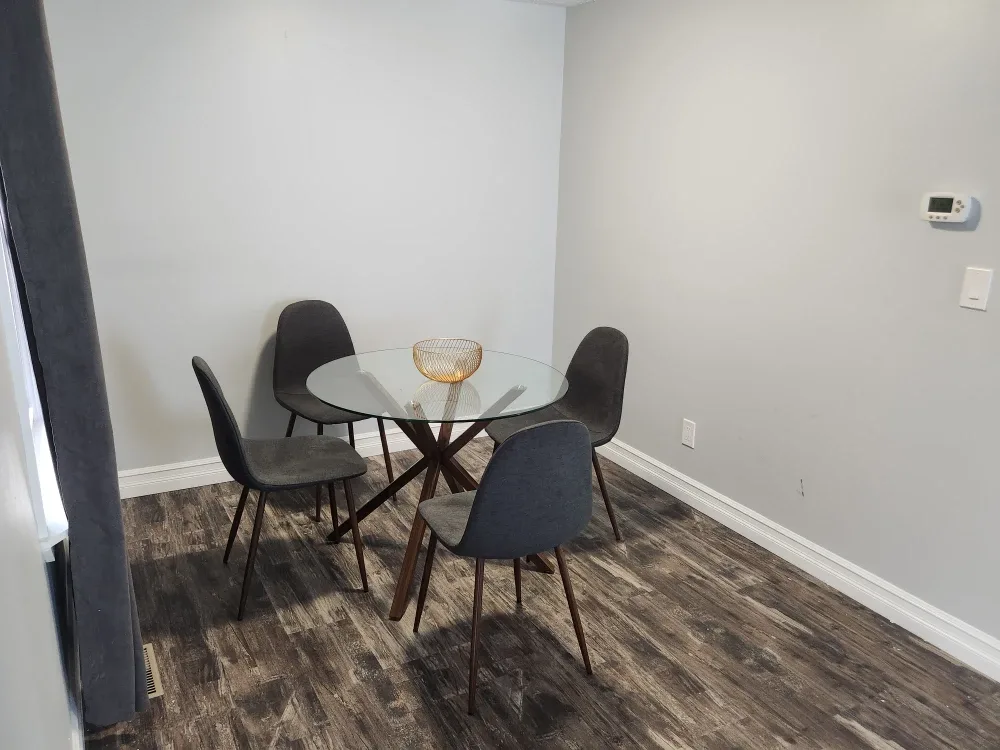 Round Glass Dining Table with 4 Grey Chairs