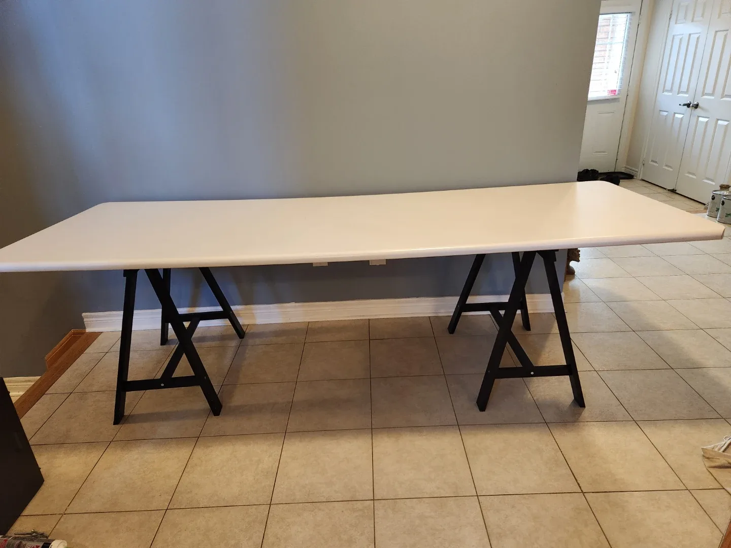 White  counter top table with black trestle legs