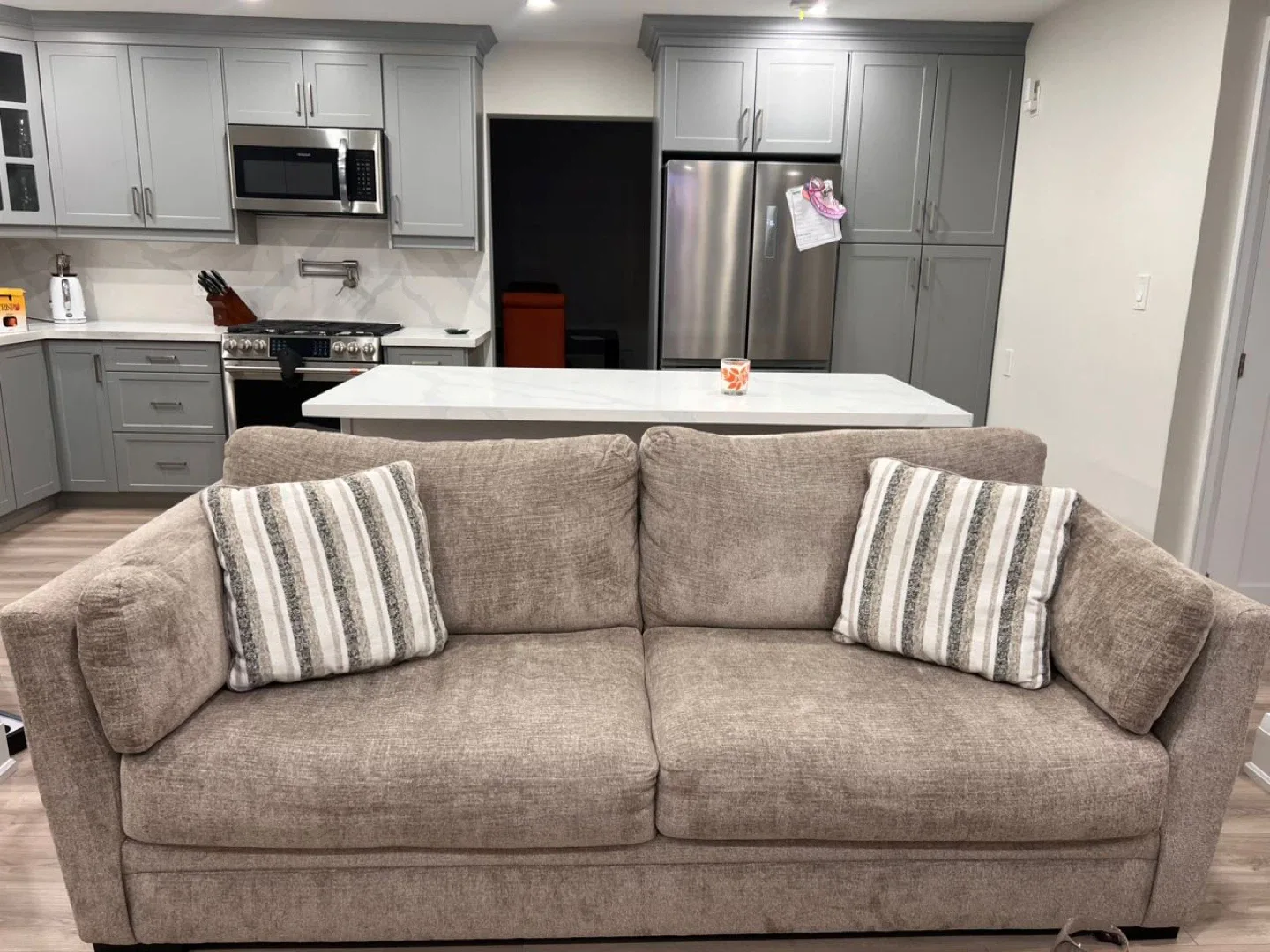 Two matching beige fabric sofas in excellent condition.