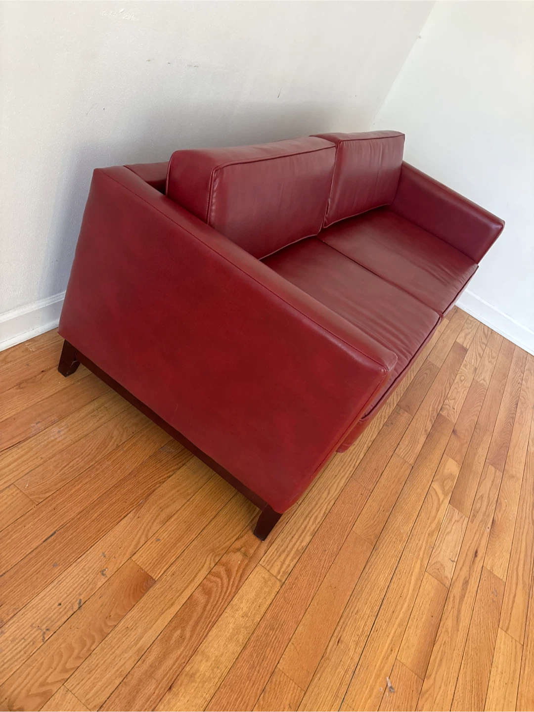 Small red leather couch . Has a wood frame . - photo 2