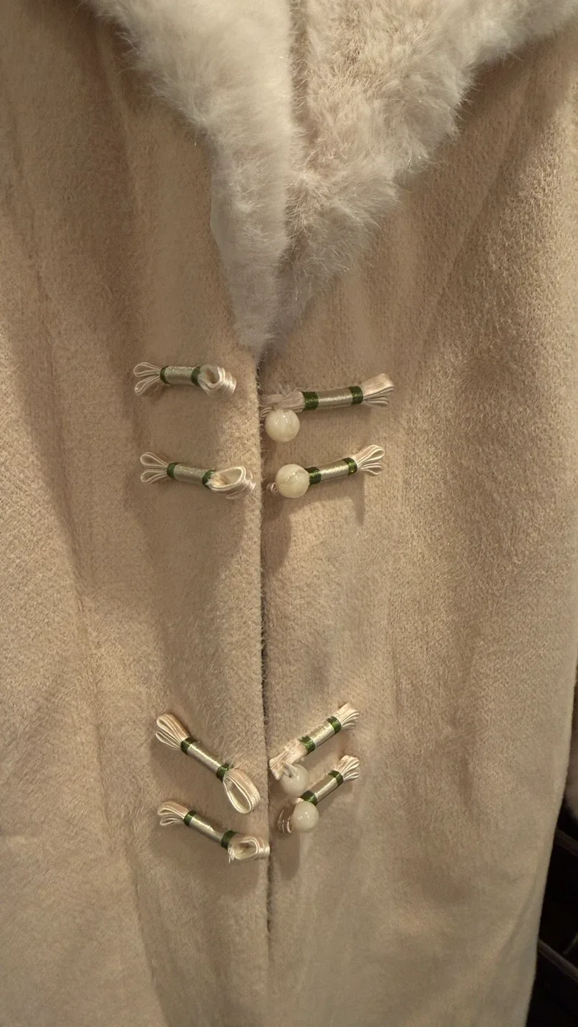 Long beige coat with faux fur trim and unique button image indicator(2)