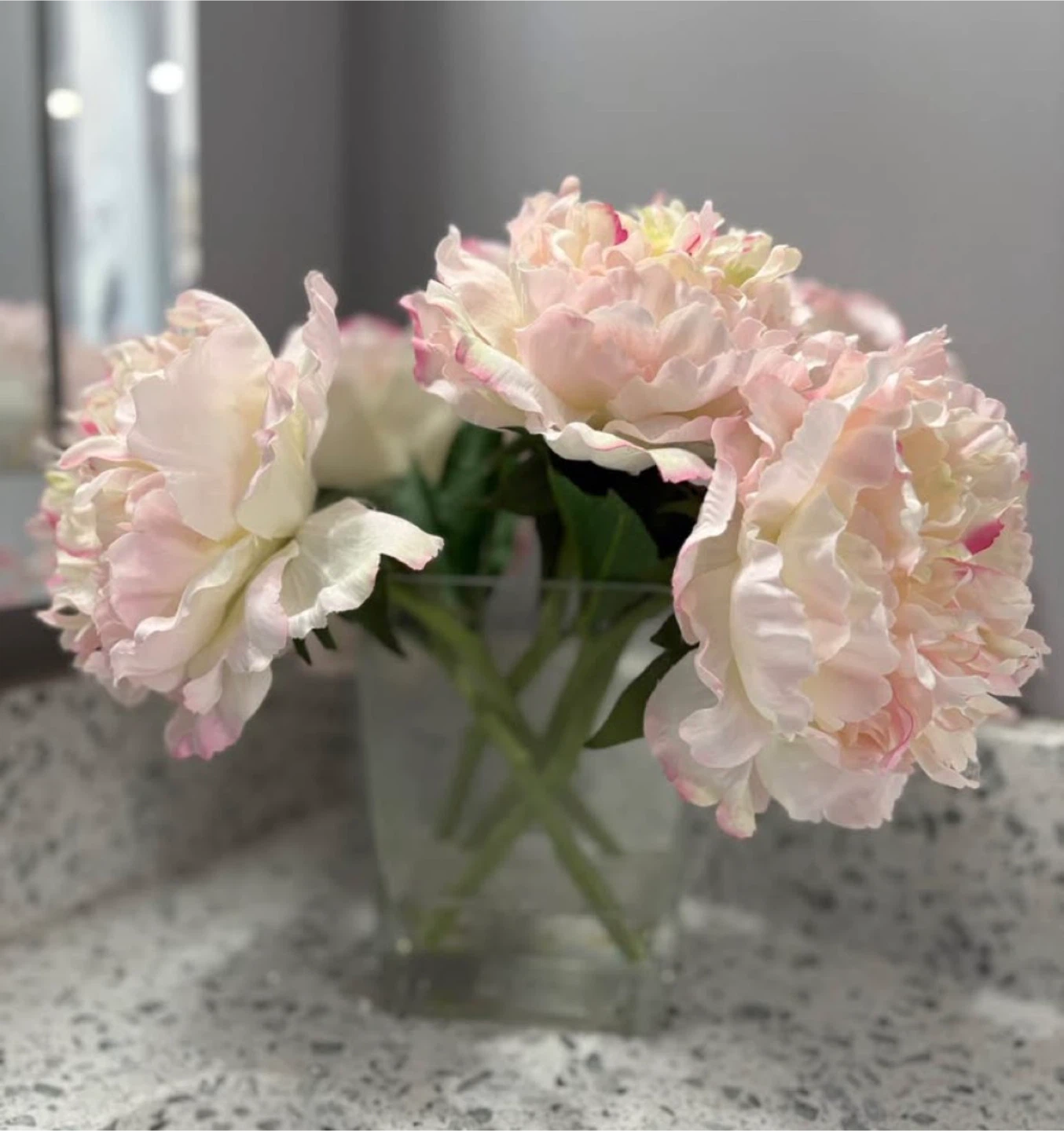 Glass vase with artificial peonies