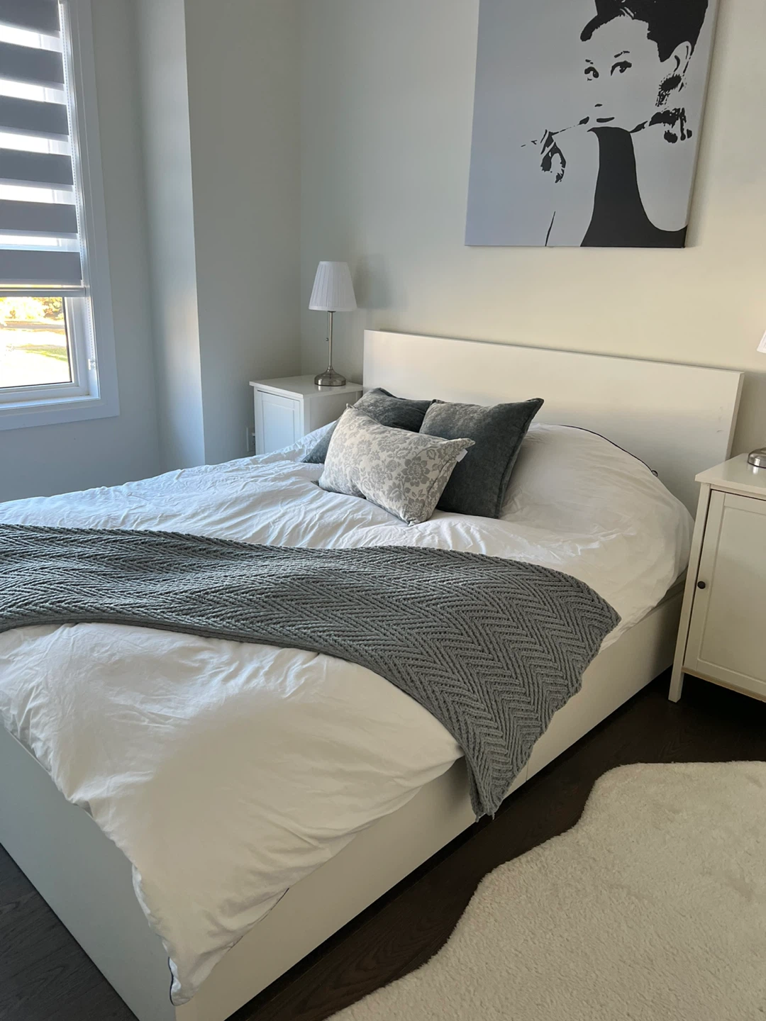 Bedroom set with bed, side tables, and artwork