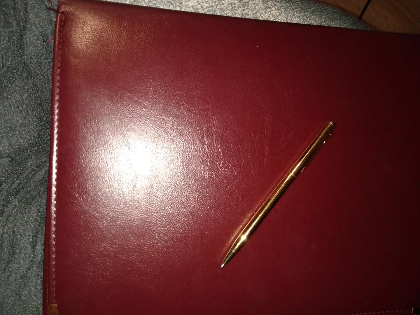 Leather portfolio with gold trim as well as a gold pen