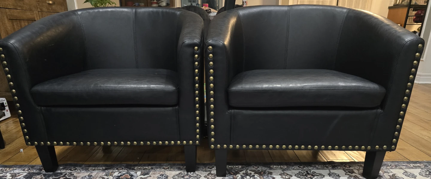 Two Black Faux Leather Barrel Accent Chairs