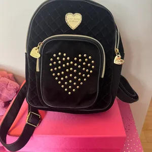 betsy johnson black heart backpack mini Forever Yours Just Peachy Clear PVC mini backpack Jewel embellishments Outside zipper pocket Top handle Silver hardware Adjustable straps 10.5inH x 8inW x 5inD Teddy Mini Backpack | Brown