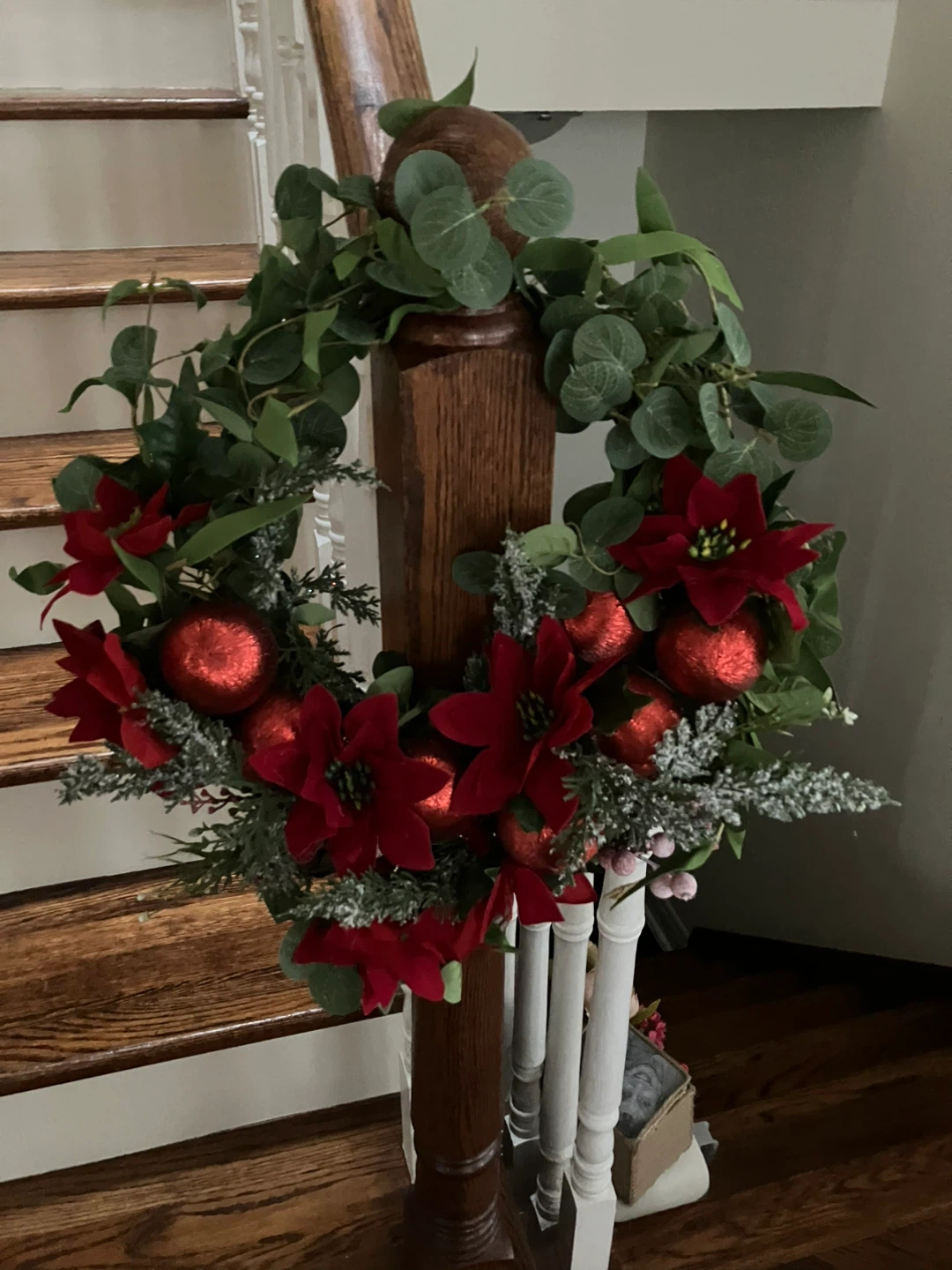 Wreath with red balls and poinsettia flowers.