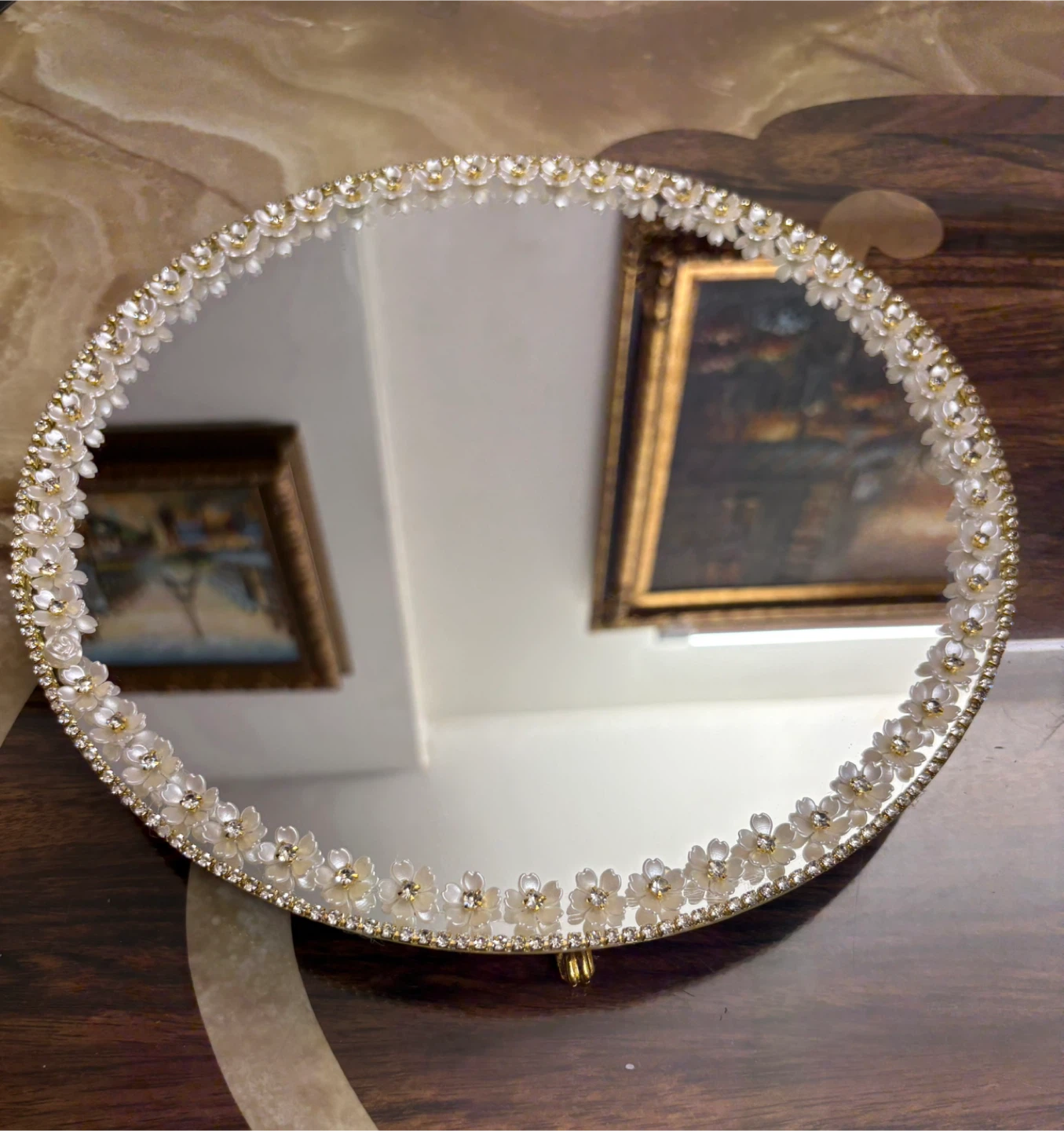Round mirror with white floral and gold rhinestone border