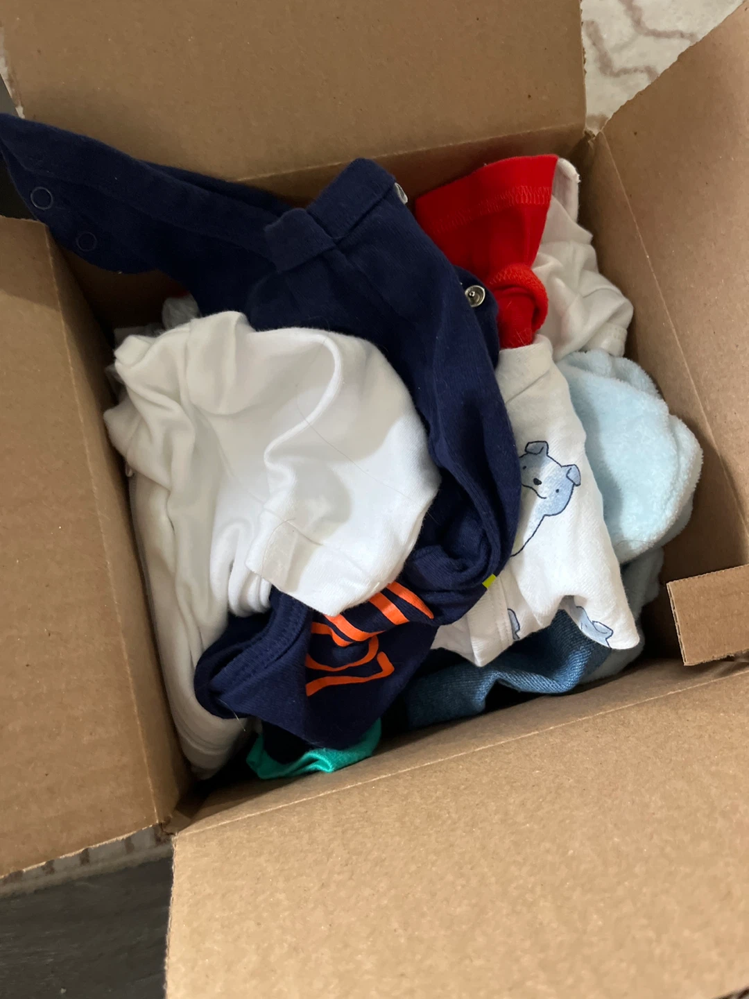 Box of assorted baby clothes