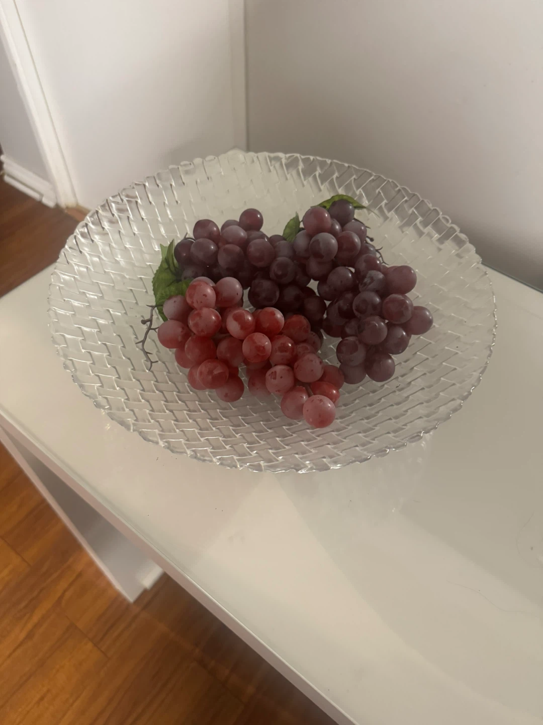 Decorative artificial grapes in glass bowl