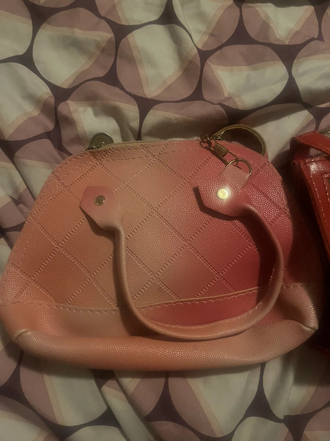Two women's purses: pink dome and red clear crossbody