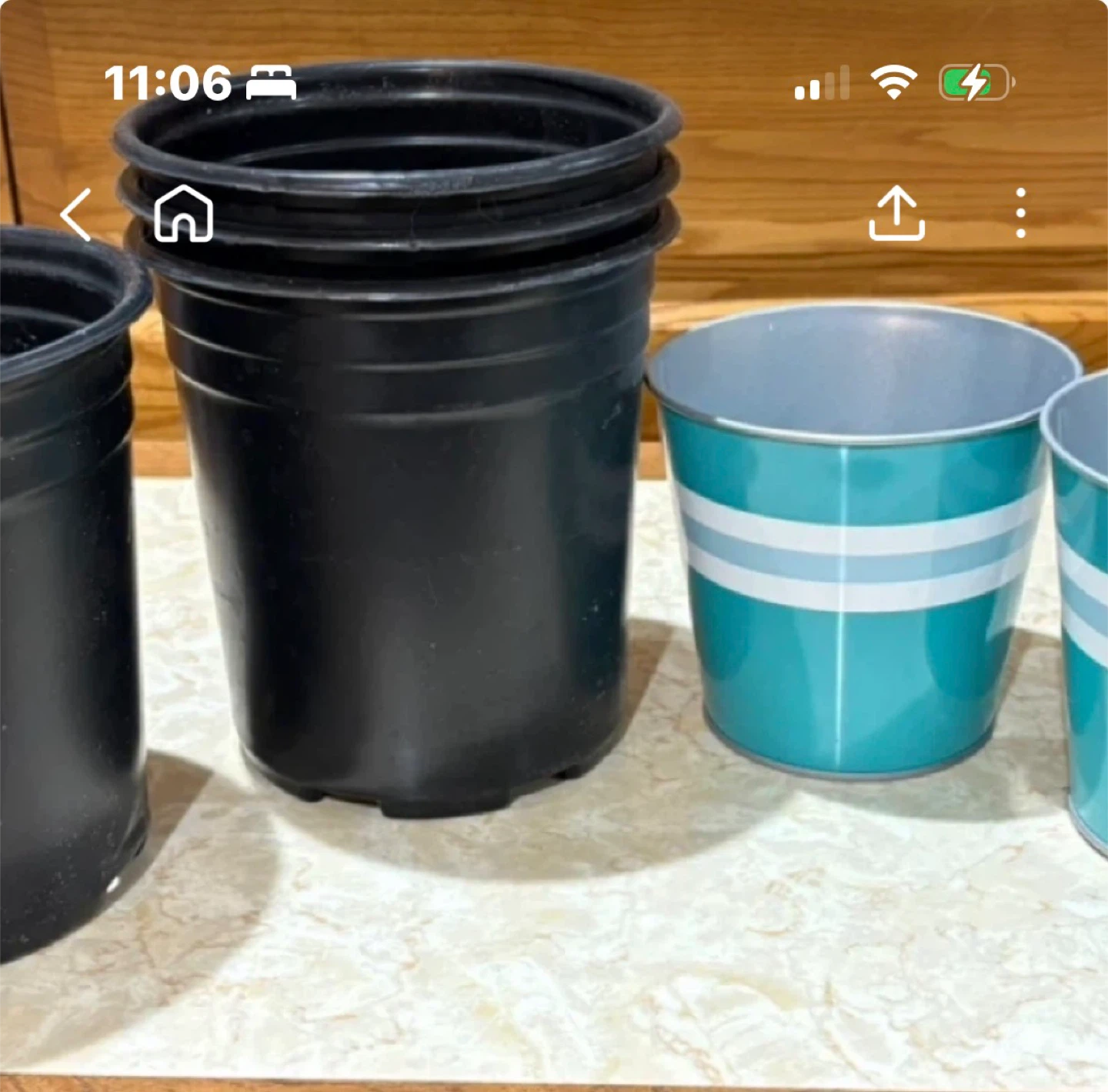 Stack of Black Plastic Plant Pots and Teal Decorative Pots