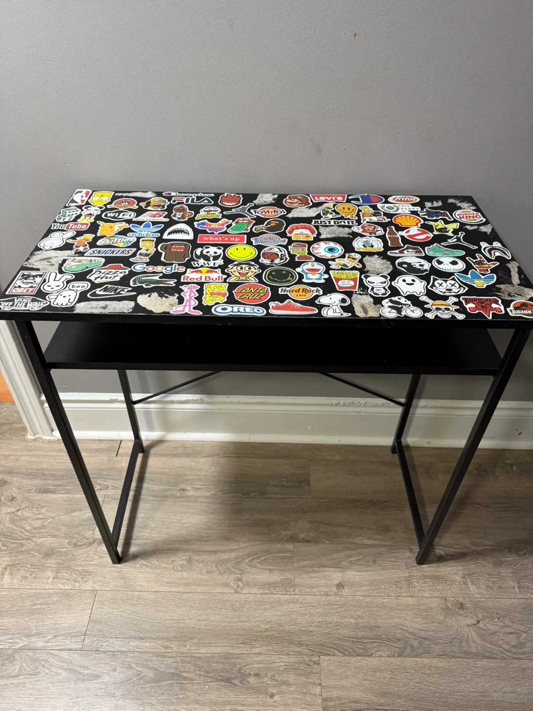 Sticker-Covered Black Desk with Shelf