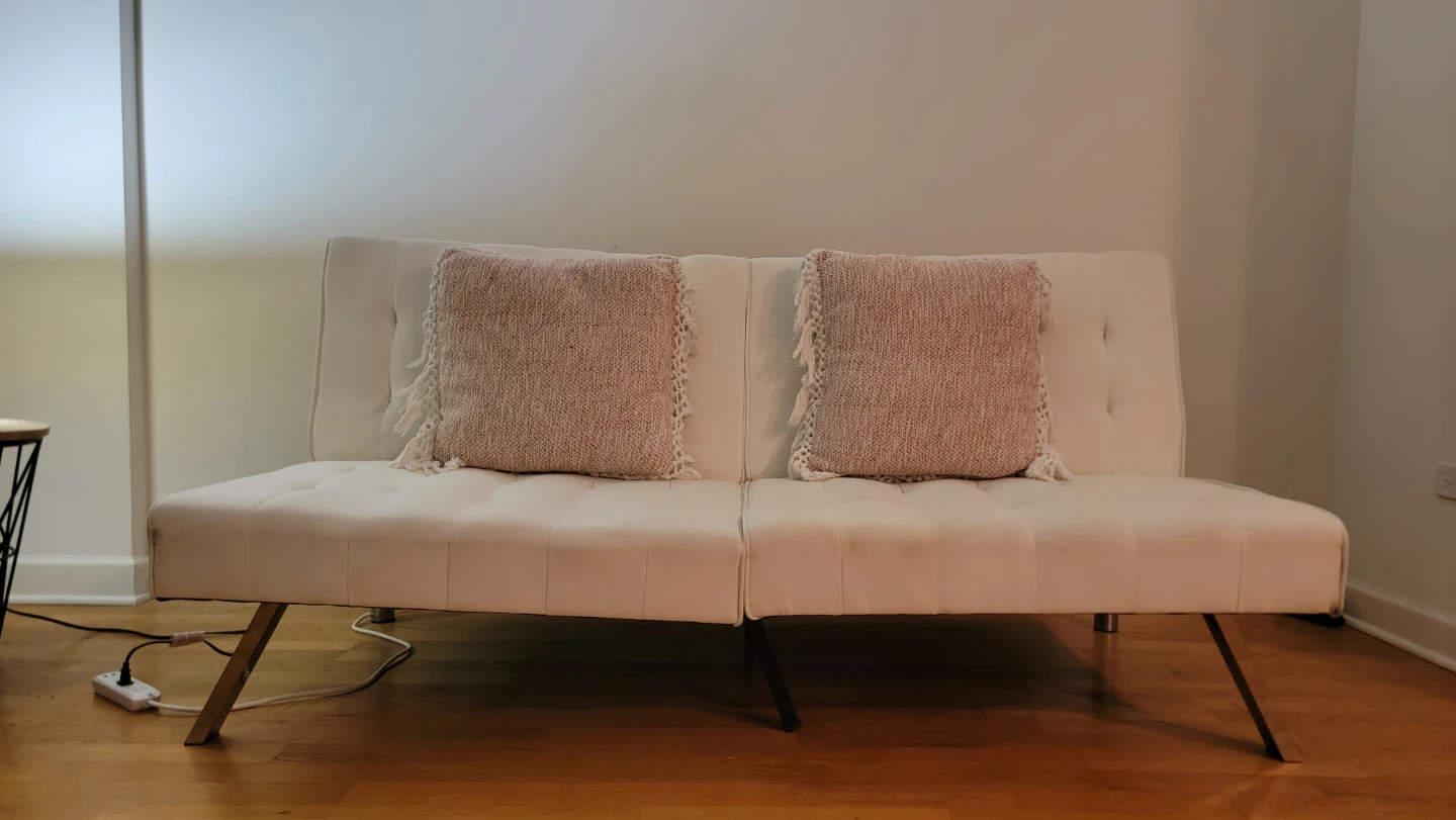 Convertible White Futon Sofa with Pink Pillows