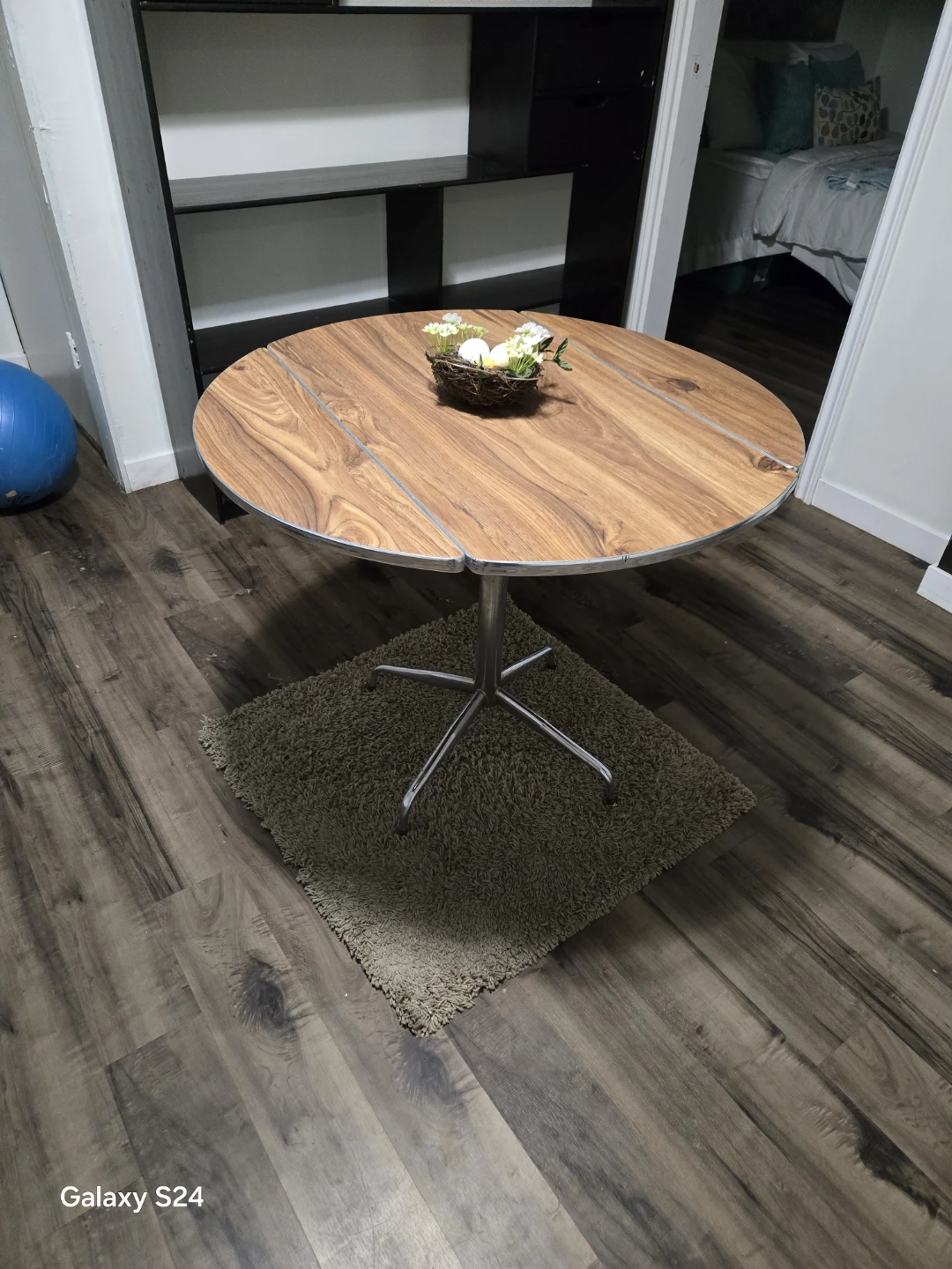 Round wooden pedestal dining table with drop-leaf sides