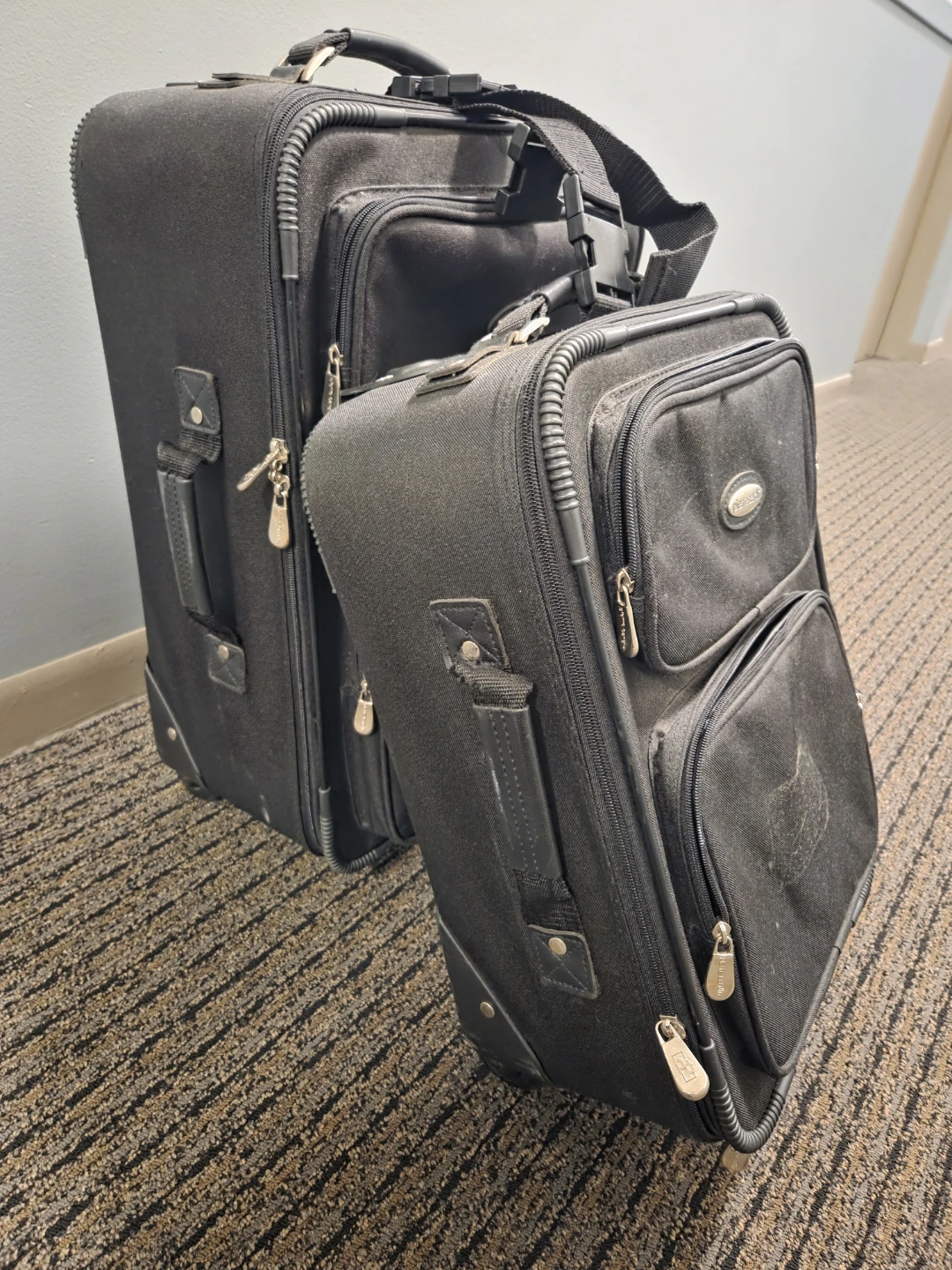Two Black Rolling Suitcases