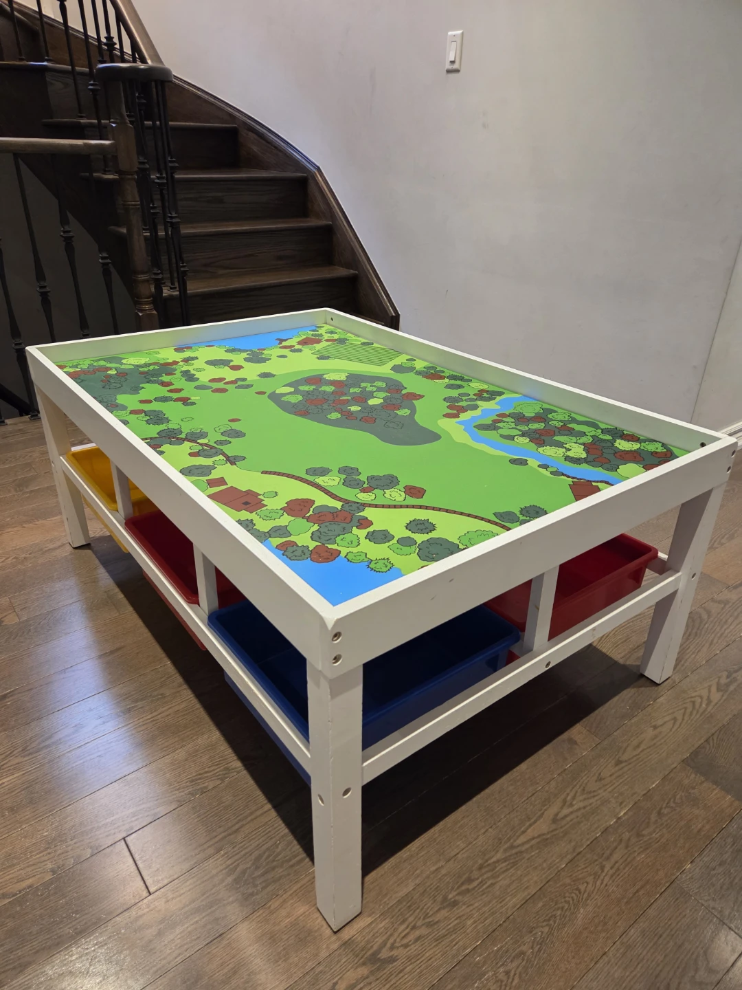 Activity table with six storage bins , train tracks and trains