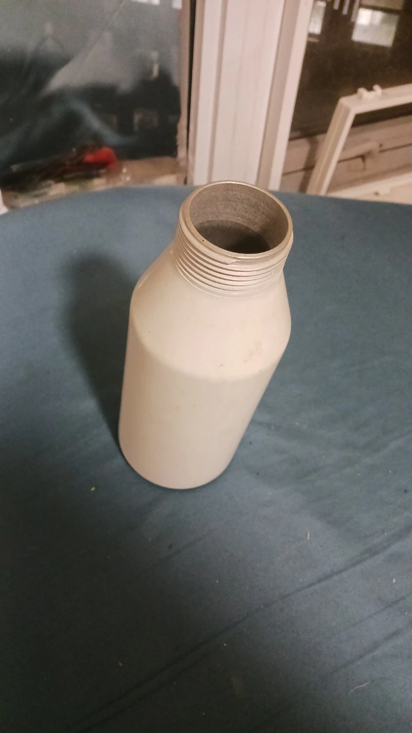 Empty cream-coloured aluminum bottle