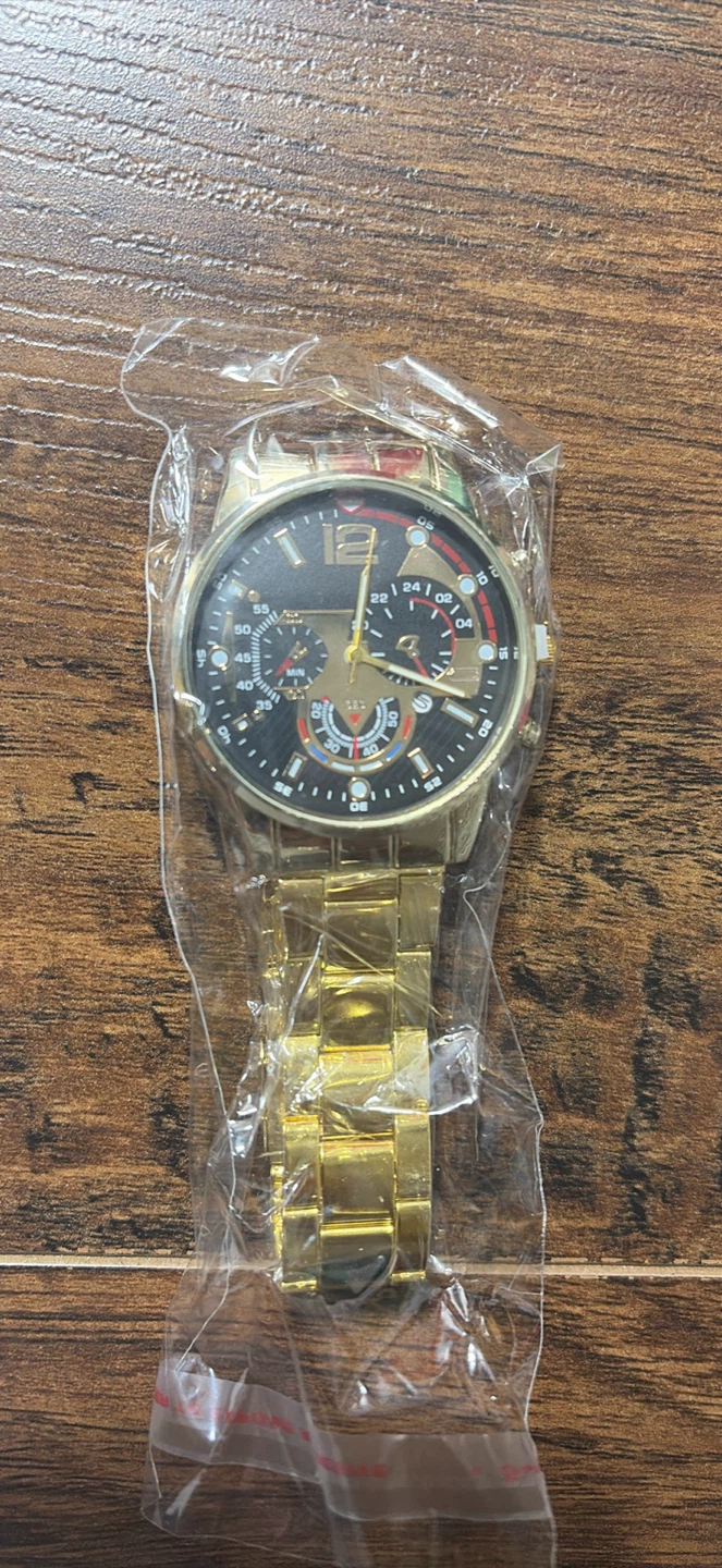 Gold tone chronograph watch with black face