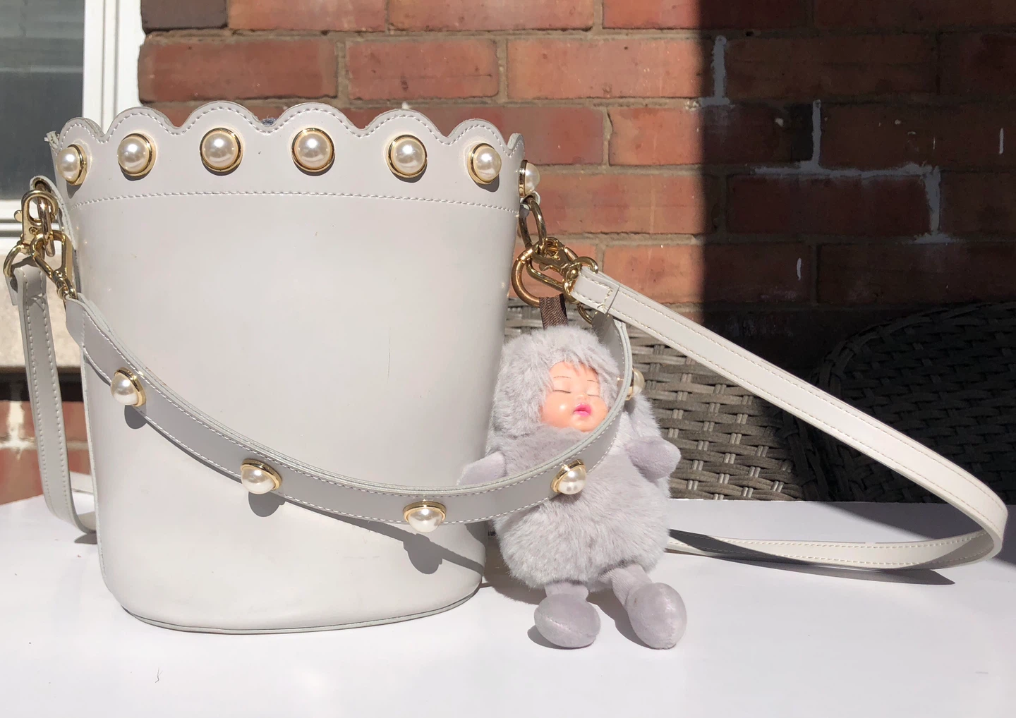 Grey bucket bag with pearl details and fuzzy charm