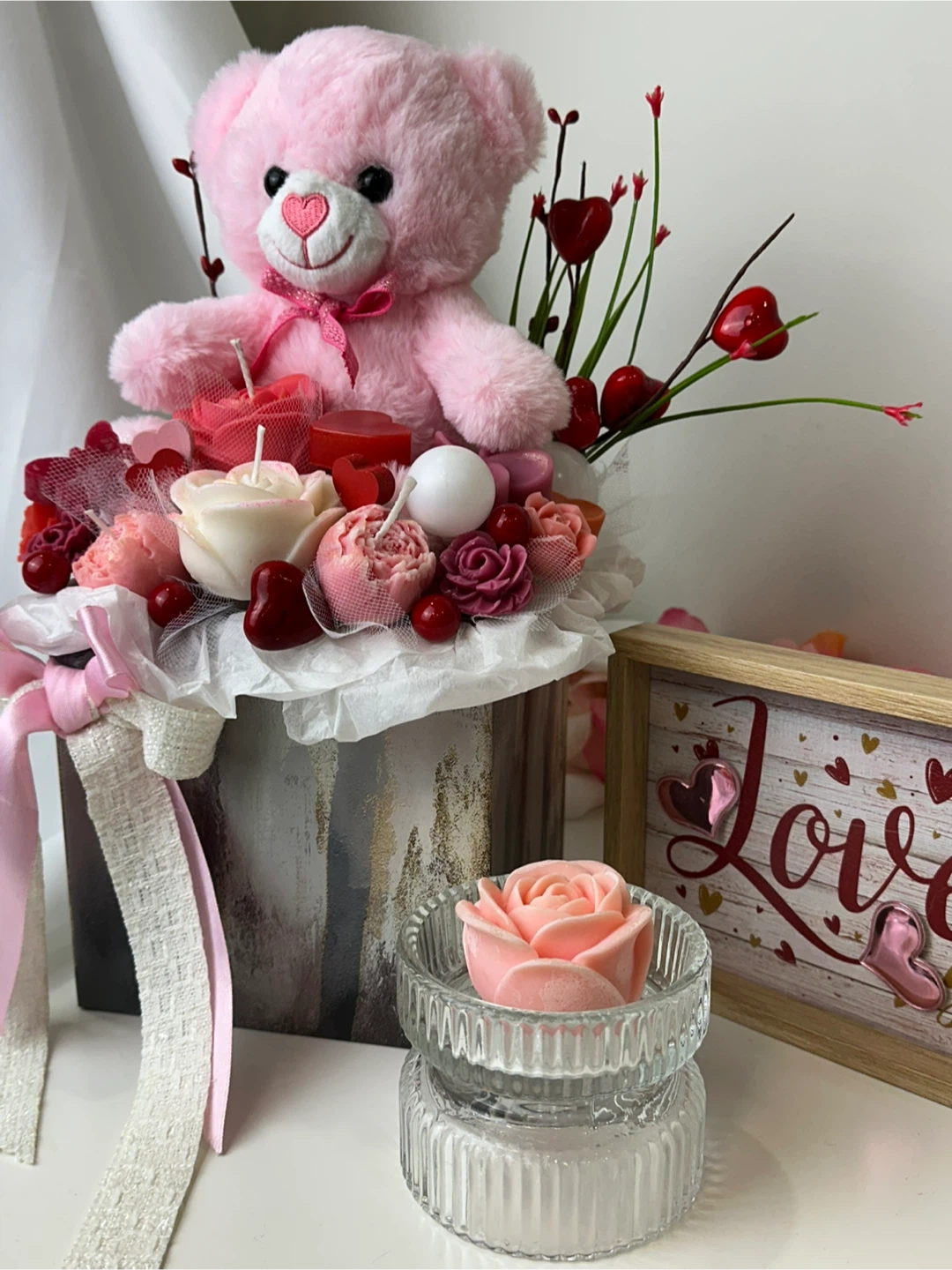 A delicate bouquet of candles with a teddy bear