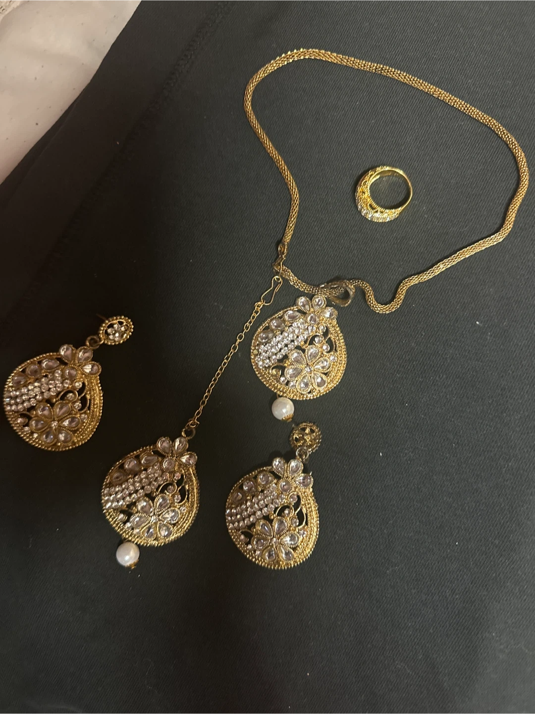 Gold-coloured jewellery set with ring, earrings, and necklace