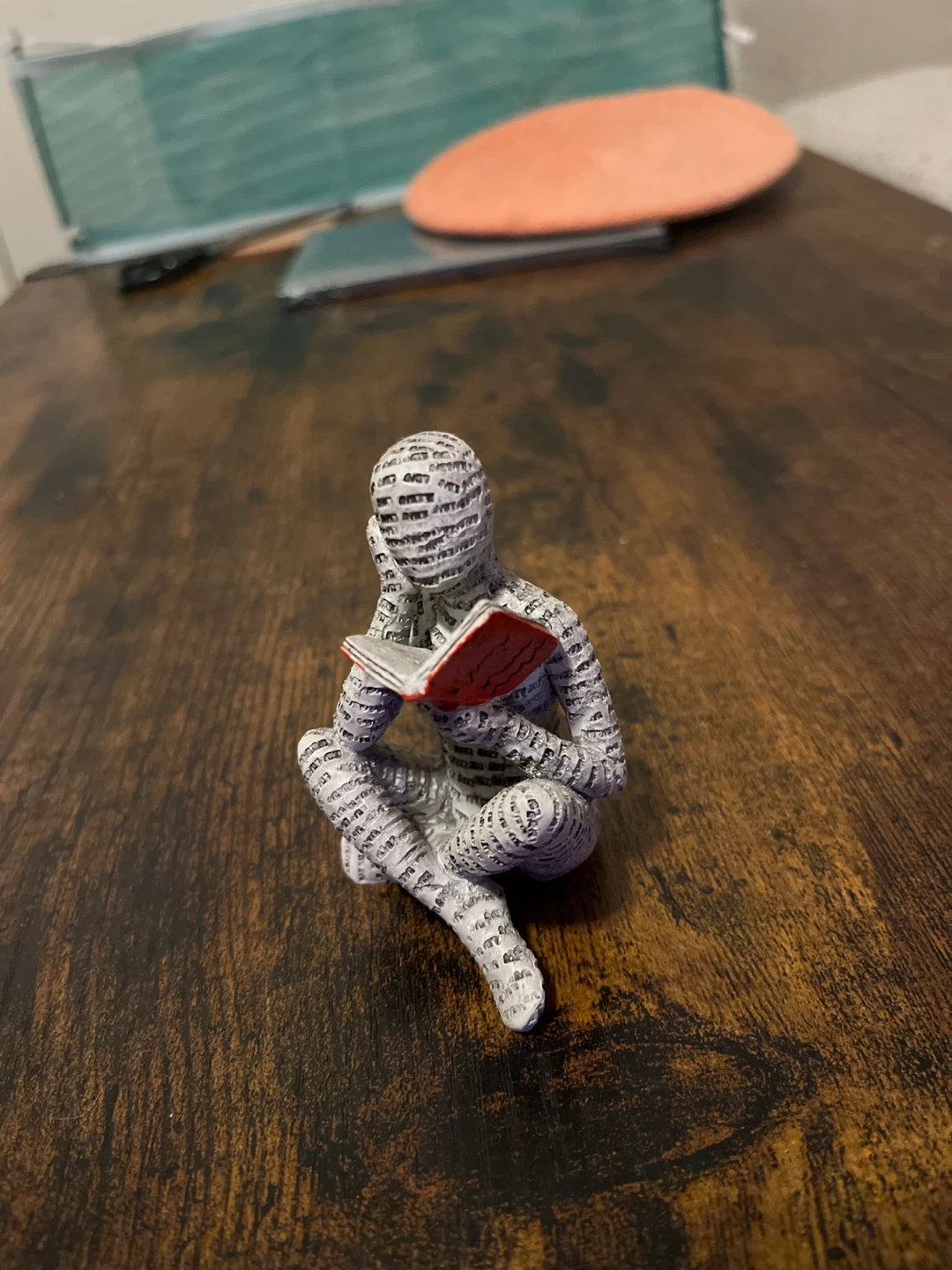 Figurine of a person reading, covered in text