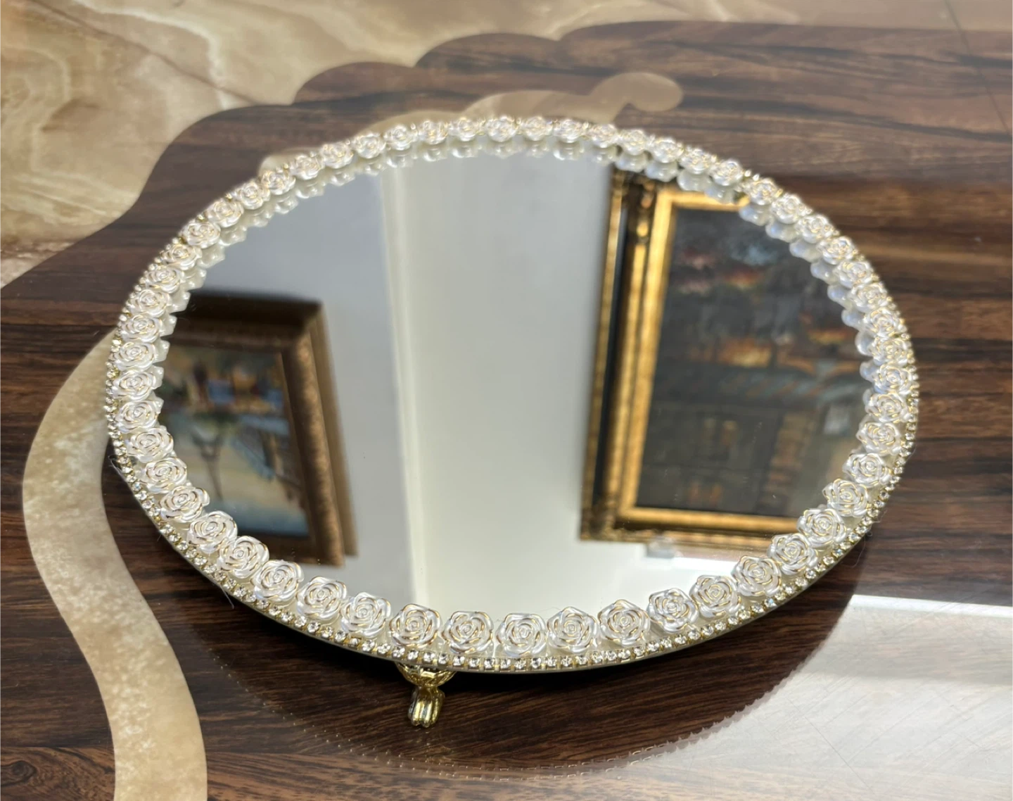 round mirror with white floral and gold rhinestone