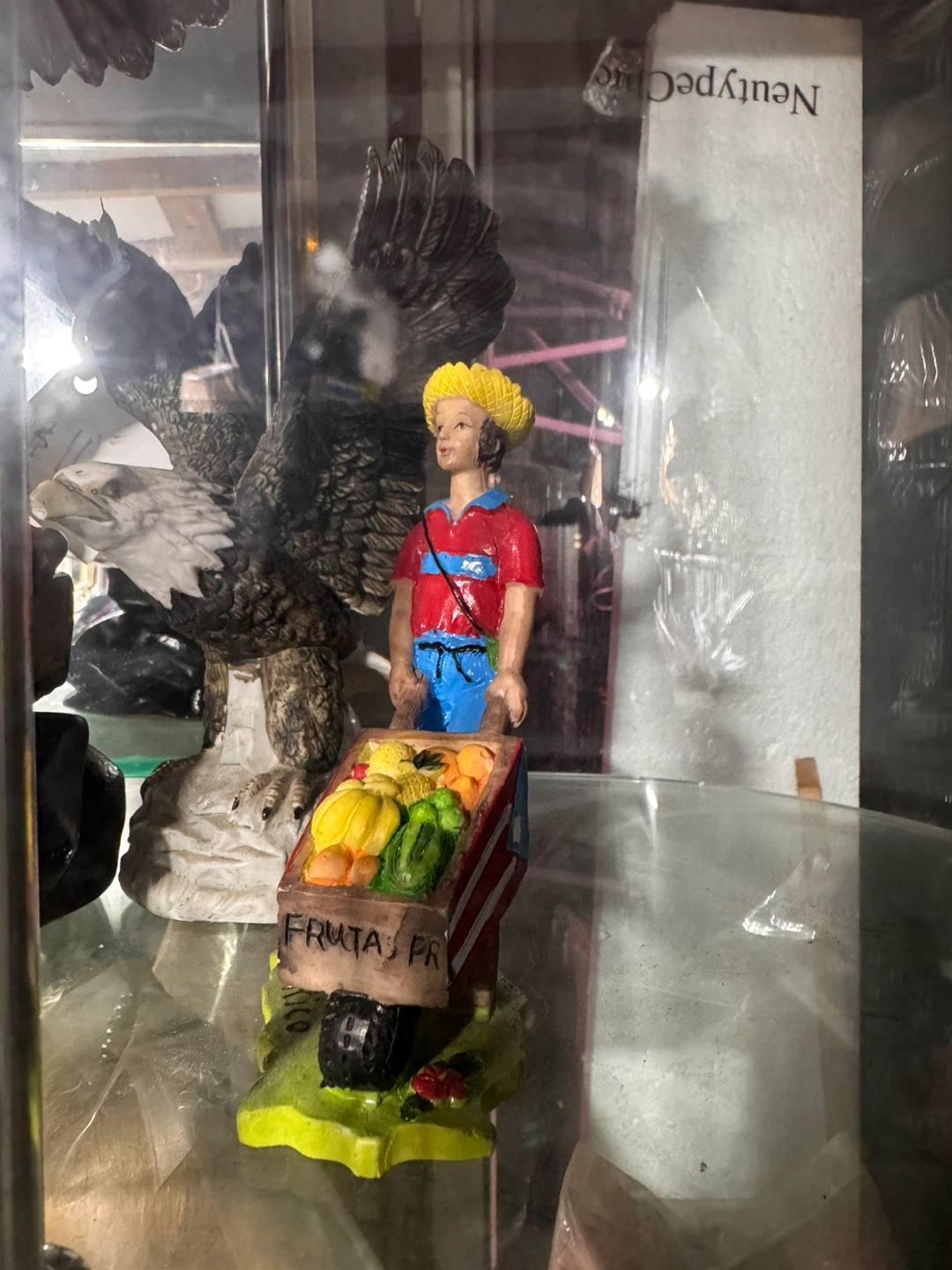 Figurine of a person with a fruit cart and an eagle