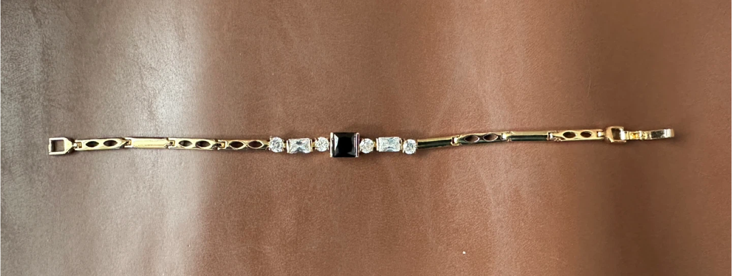 Gold tone bracelet with black and clear stones
