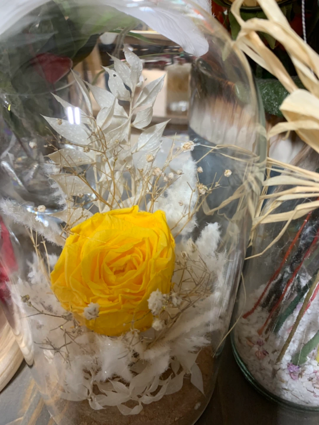 Preserved yellow rose  white filler flower in cork based dome.