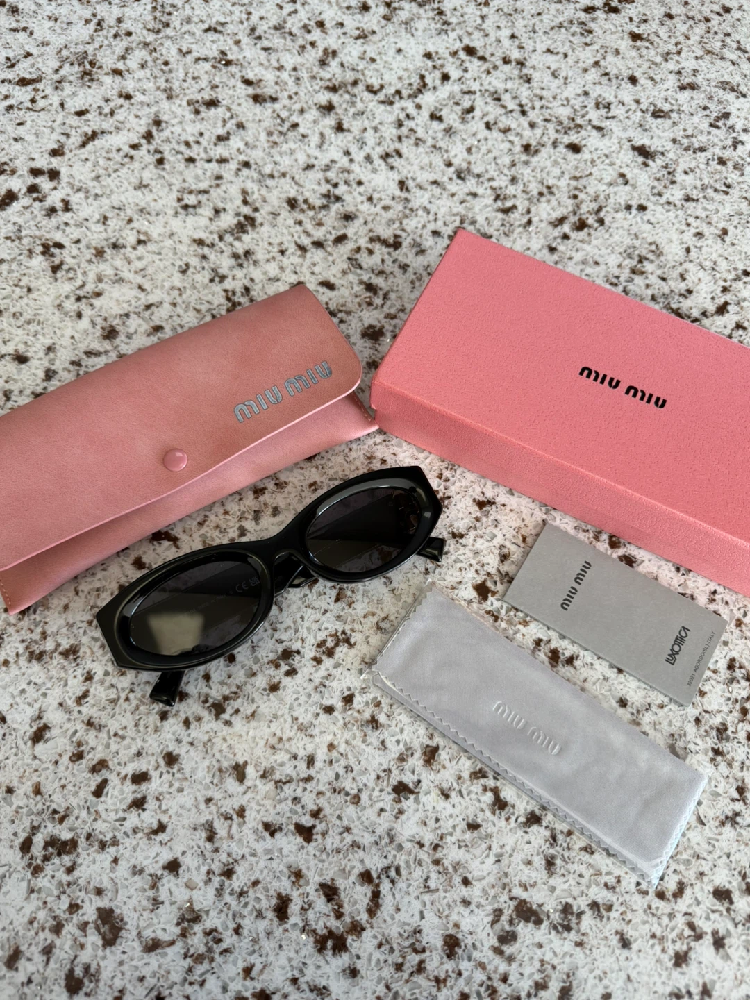 Miu Miu Black Oval Sunglasses with Gold Logo Detail