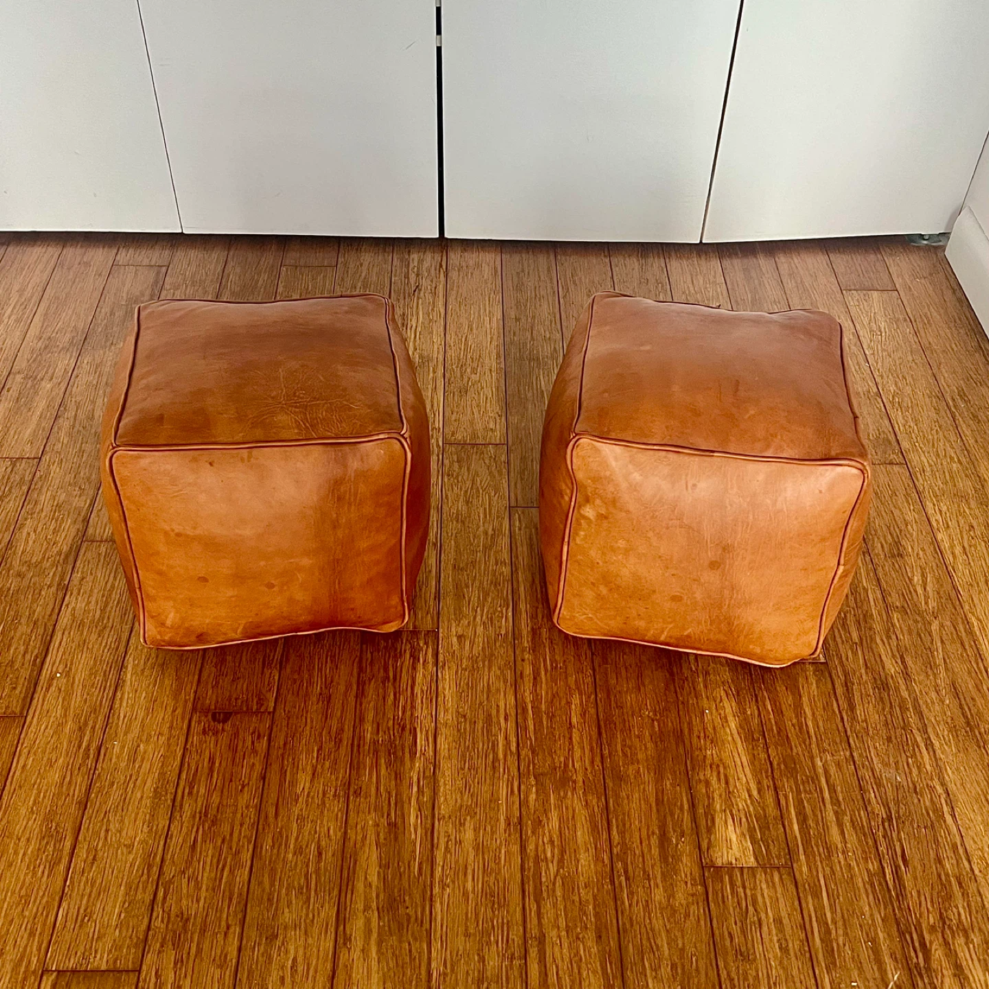 Pair of tan leather pouf/ottoman/footstools
