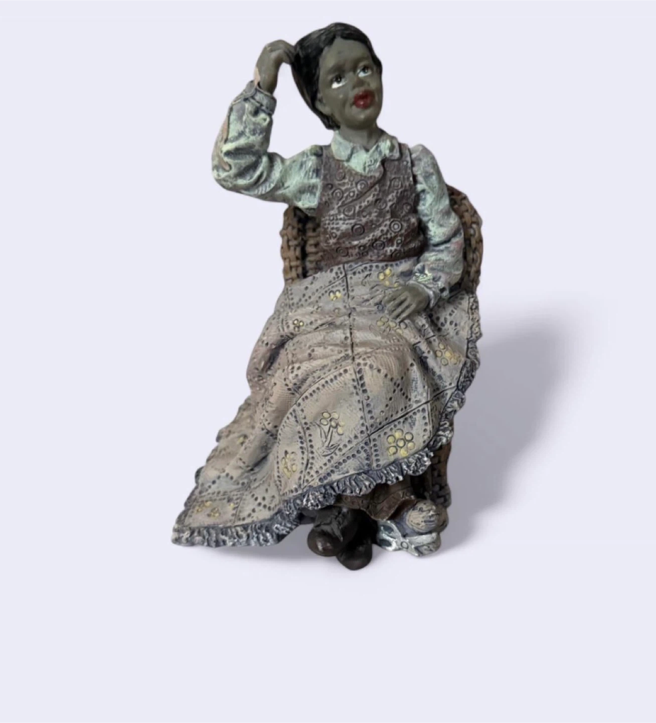 Figurine of a woman sitting in a chair