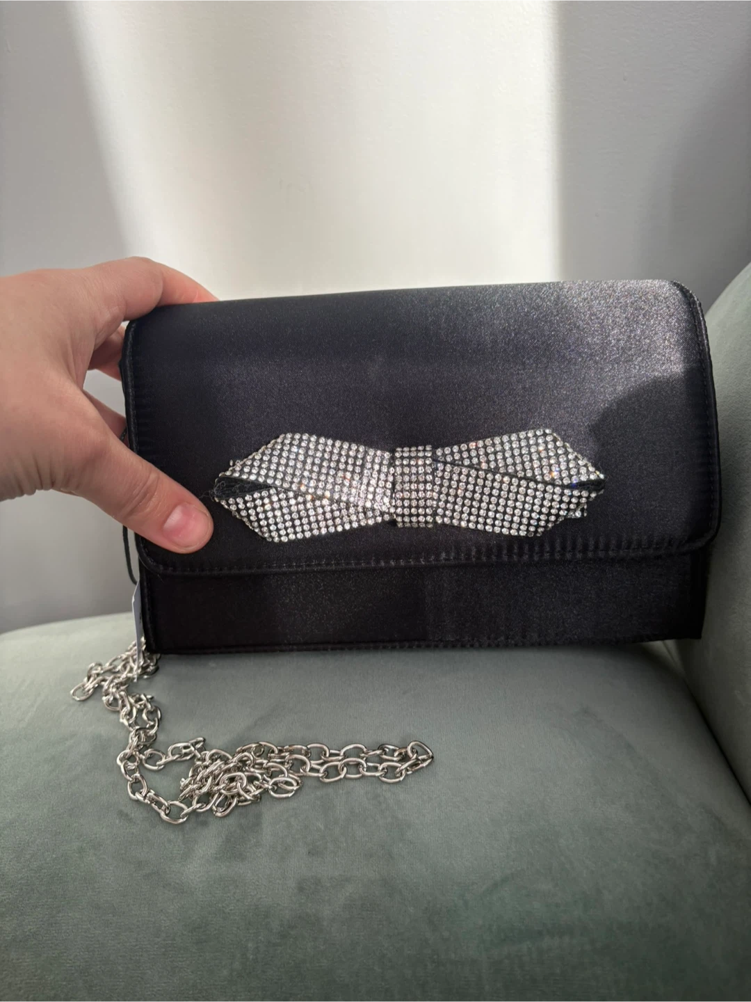 Black clutch with rhinestone bow and silver chain