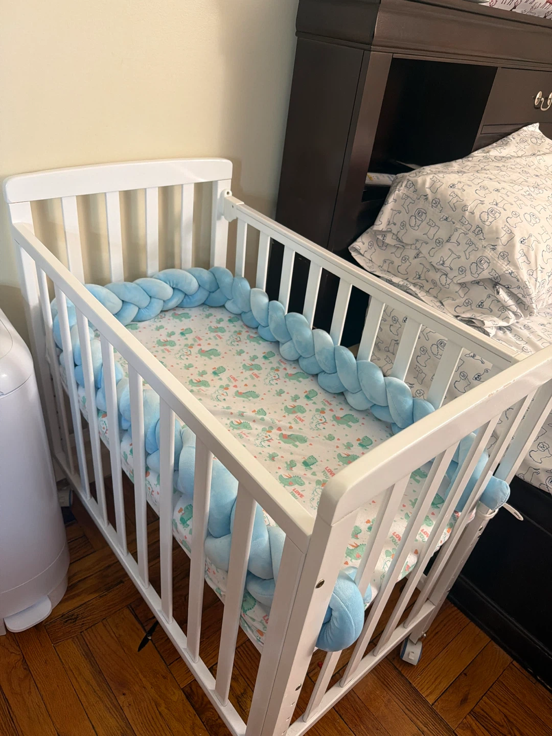 White Crib with Blue Braided Bumper and Dino Sheet