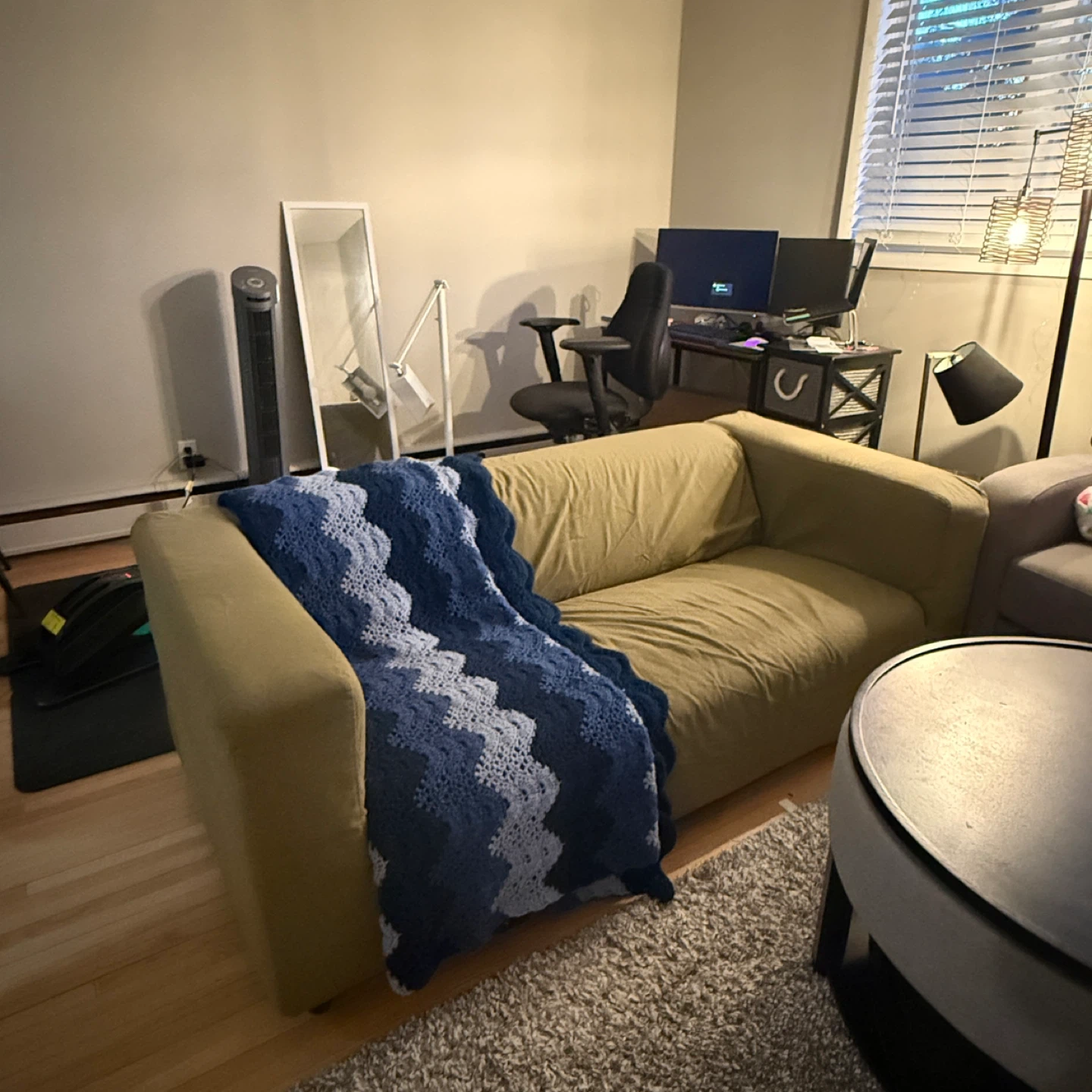 Cozy green sofa with cute knit throw