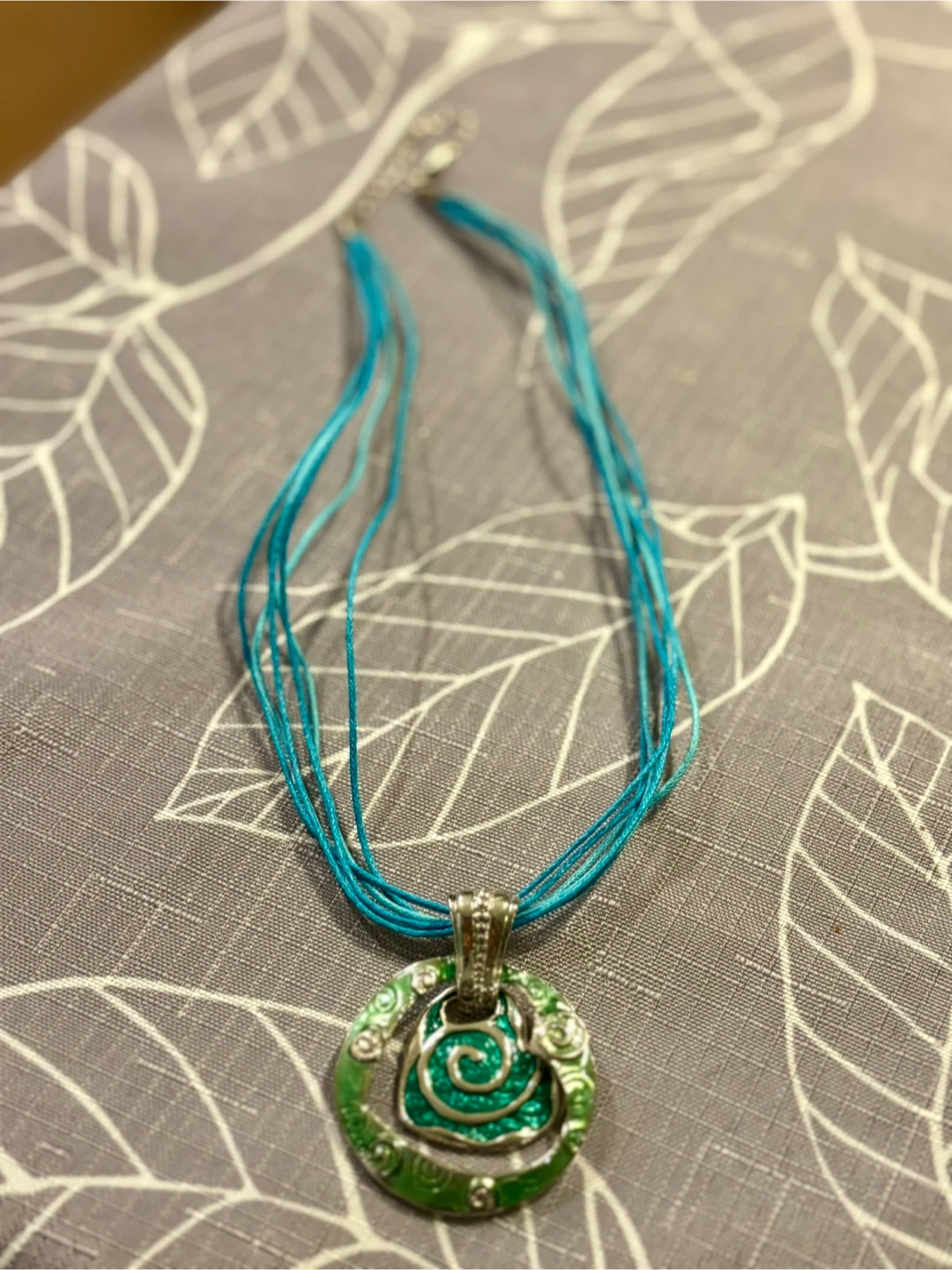 Blue multi-strand necklace with green spiral pendant