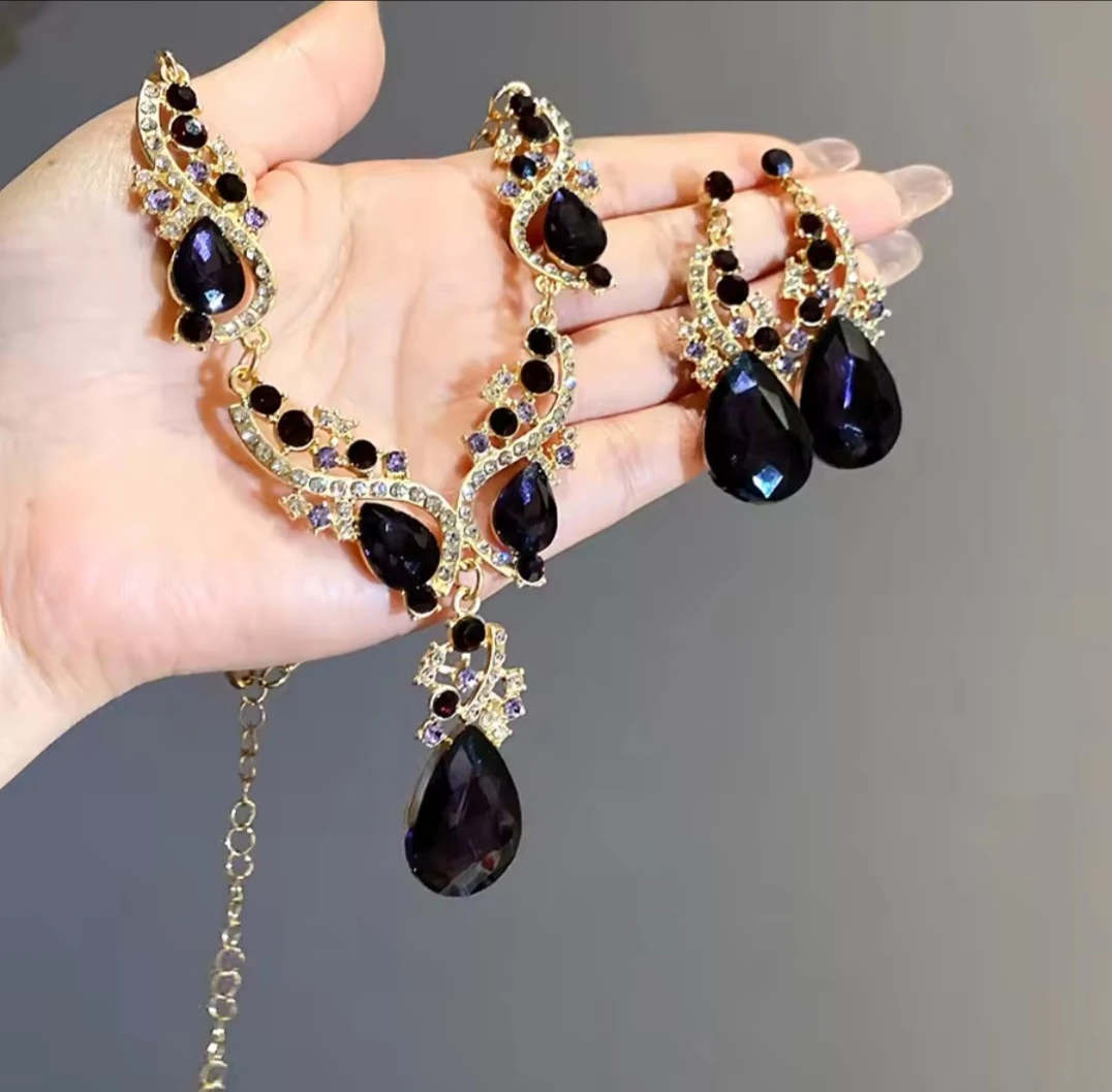 Gold-tone necklace and earrings set with dark teardrop stones