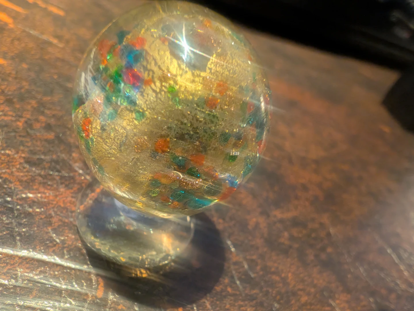 Glass snow globe with colourful flecks