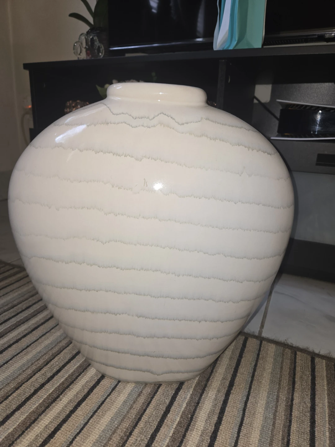 large, off-white, ribbed ceramic vase.