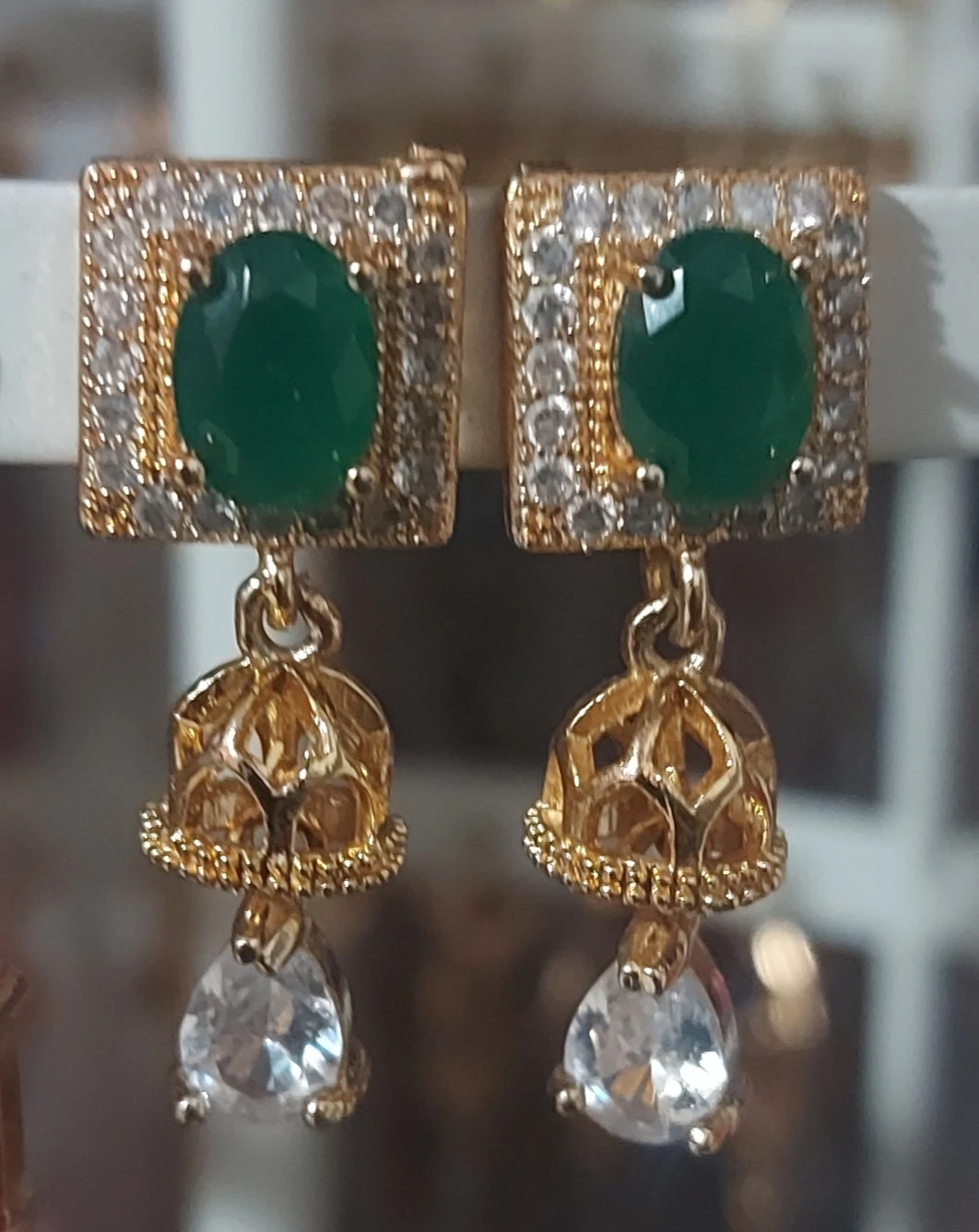 Gold tone drop earrings with green and clear stones