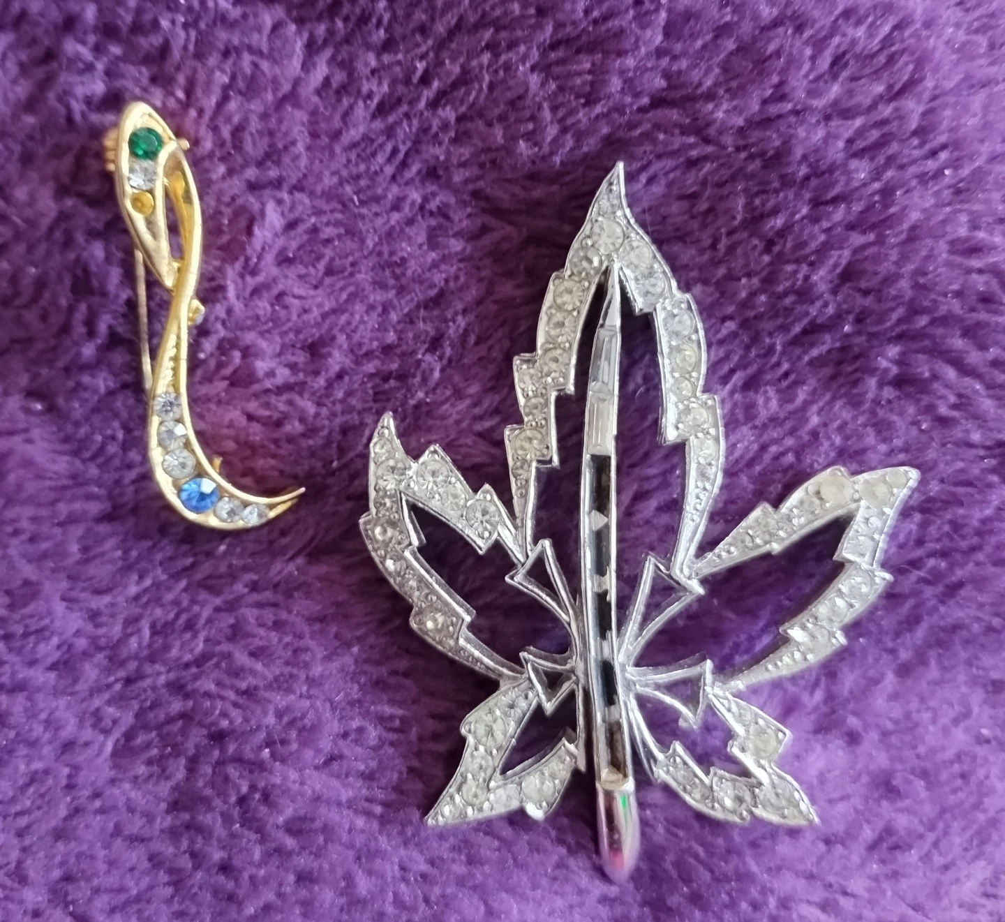 Two brooches: silver maple leaf and gold abstract
